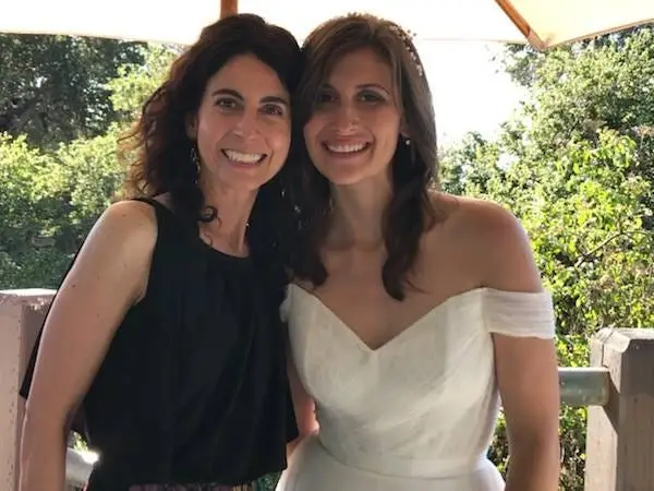 Author Cheyenne Elwell in white gown posing with woman in black dress