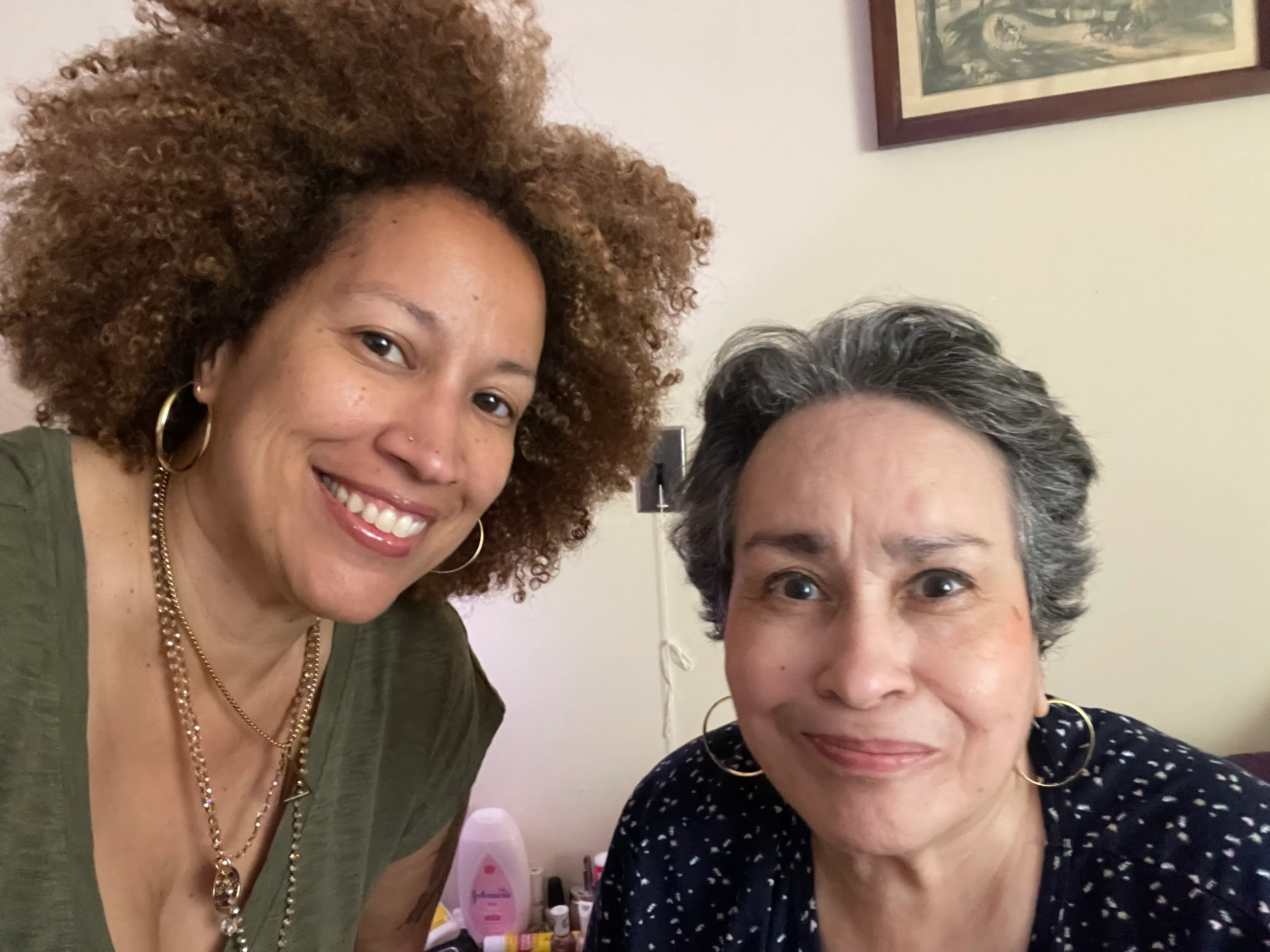 A mother and daughter smiling into the camera.