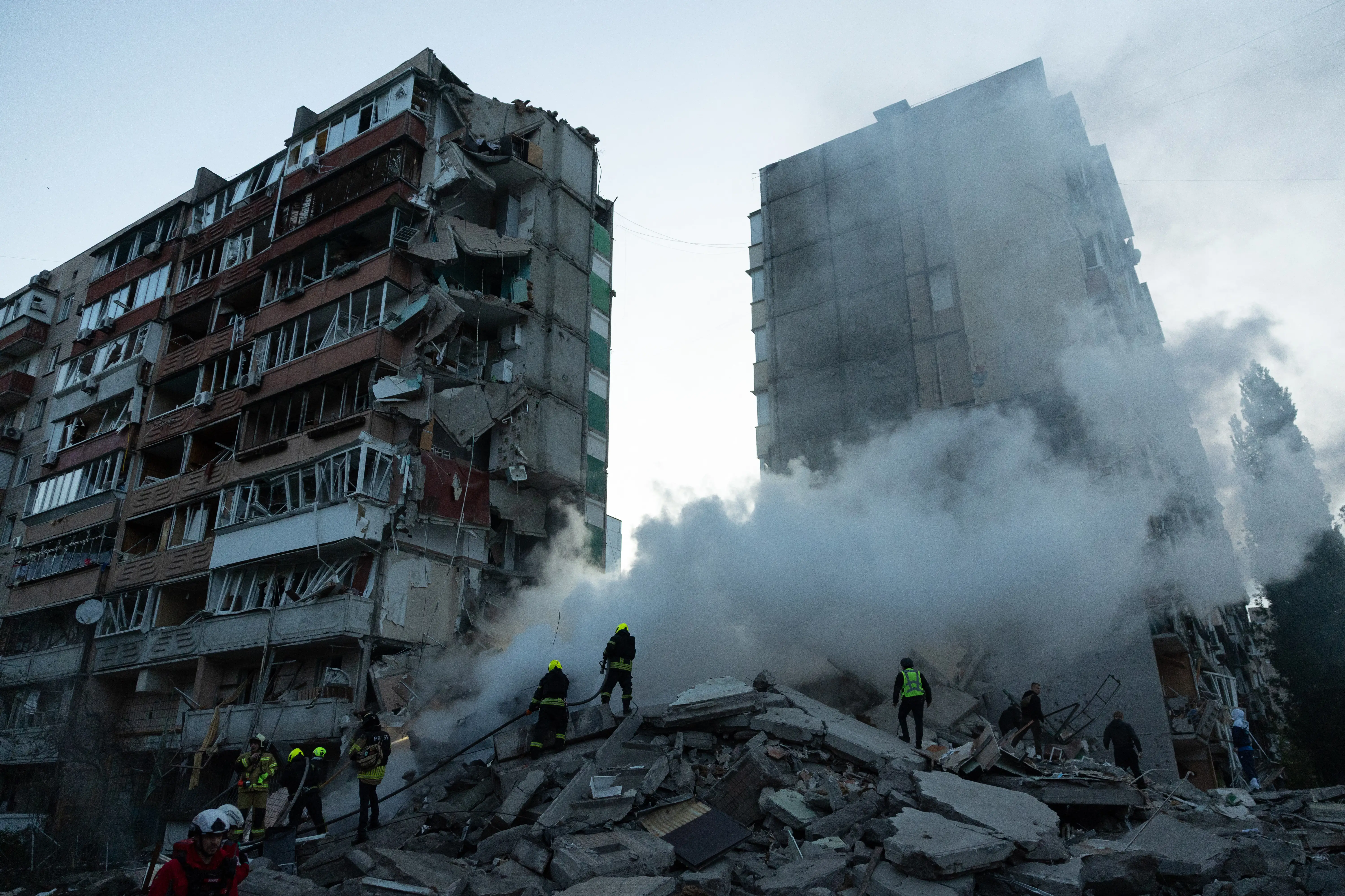 Rescuers work at a residential building partially destroyed following Russian drone and missile strikes in Kyiv on May 14, 2026.