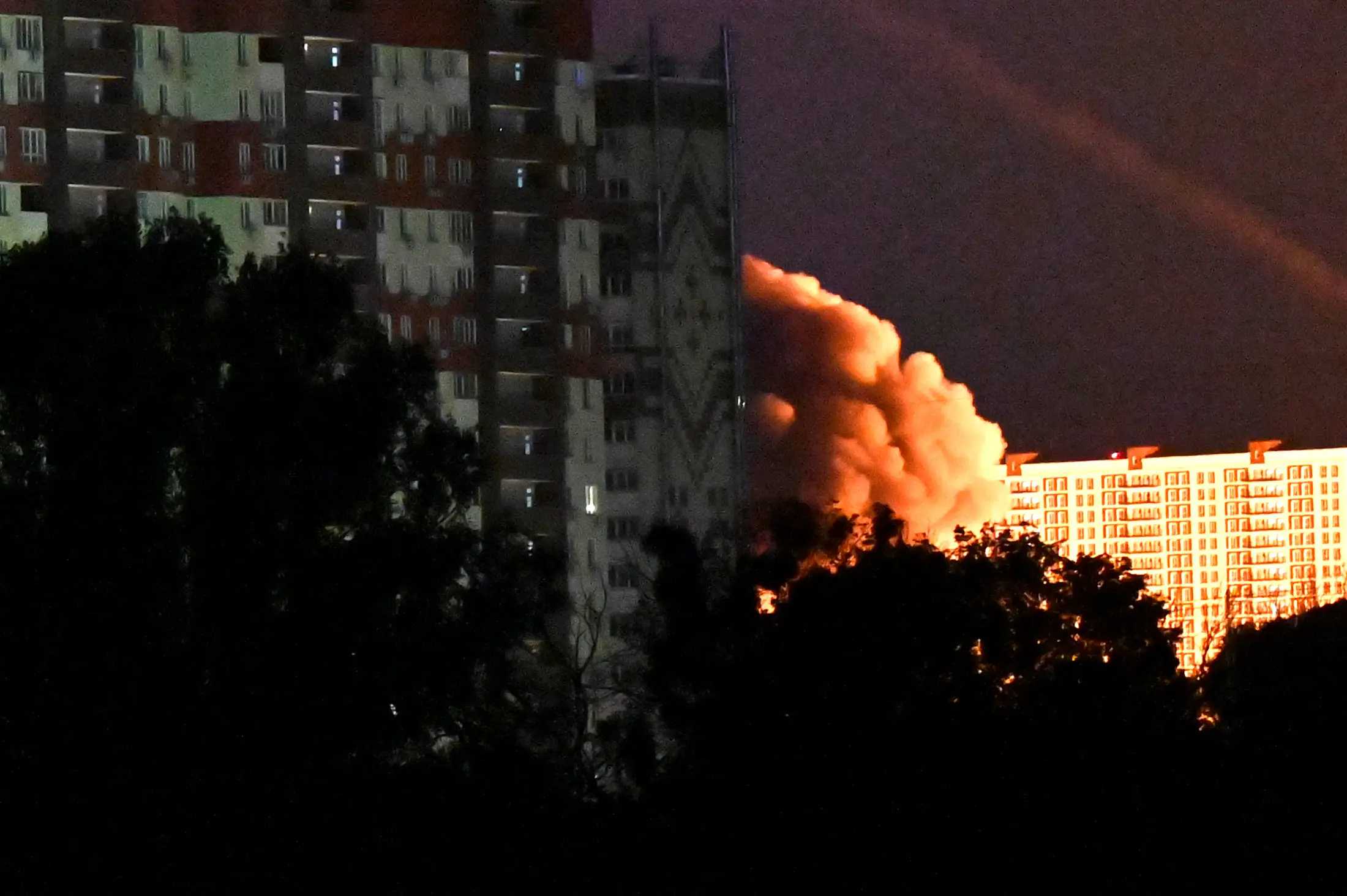 Smoke from an explosion among multi-story residential buildings is seen during Russian drone and missile strikes in Kyiv on May 14, 2026.