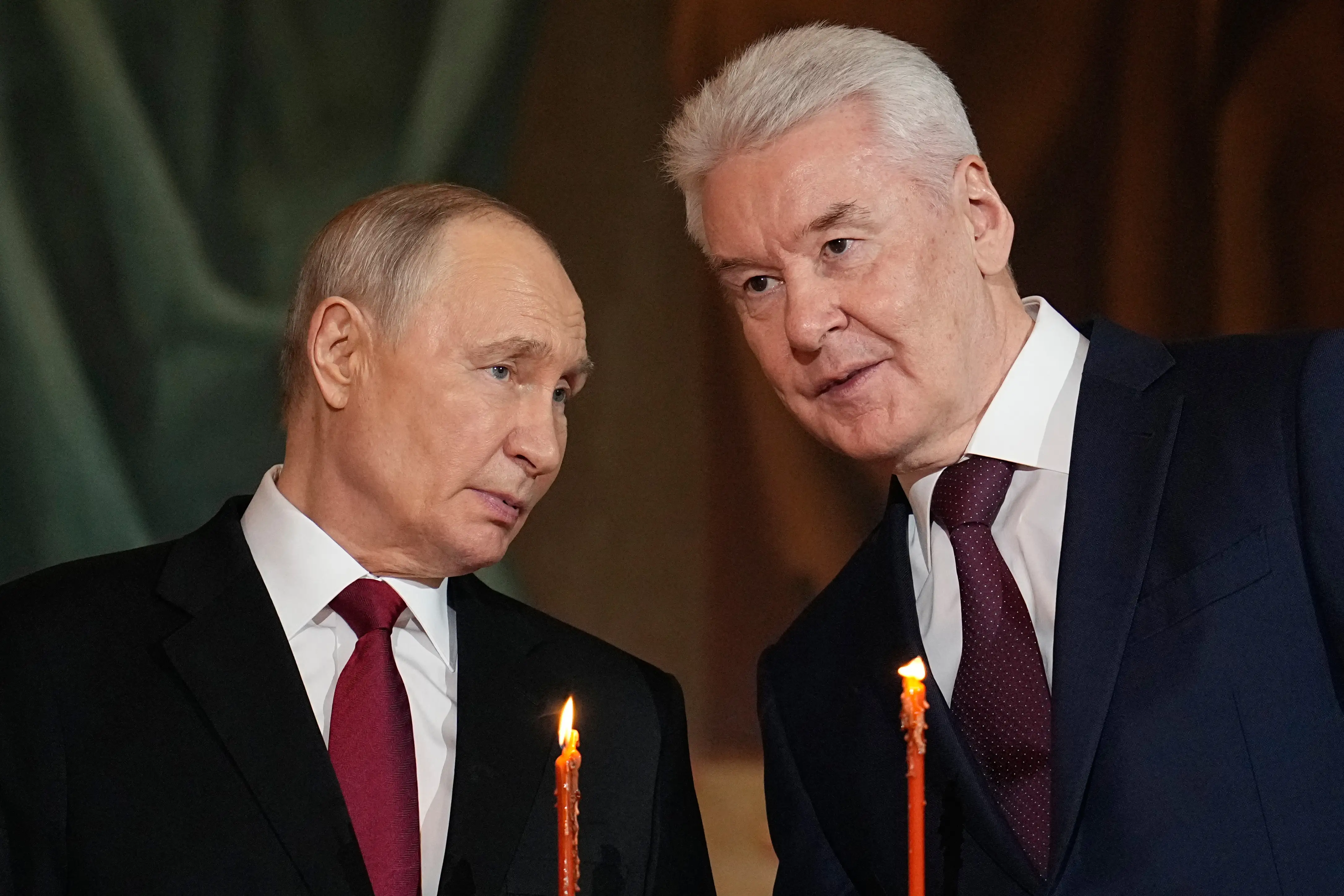 Putin and Sobyanin hold candles and speak at an Orthodox Easter Service.