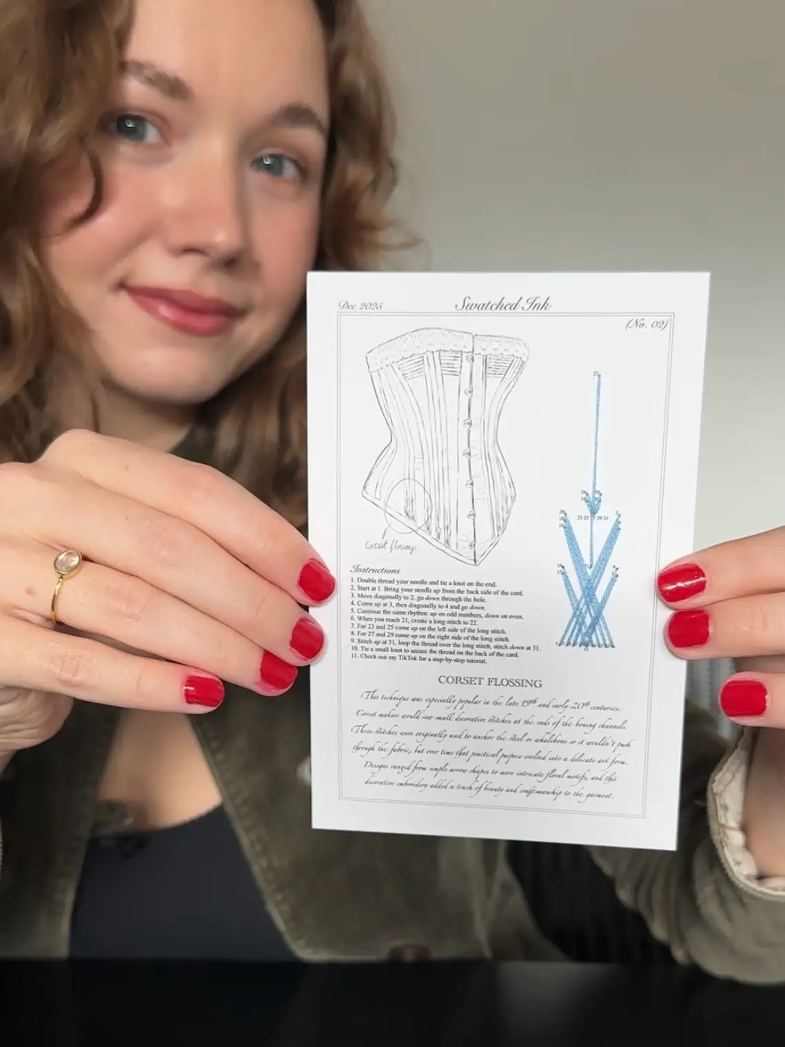 A young woman holding a piece of card.
