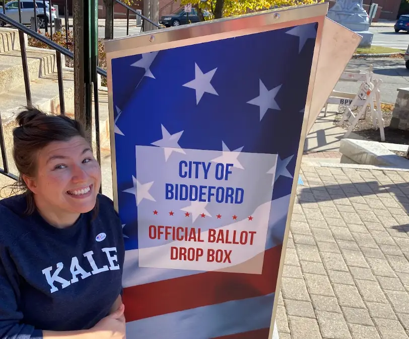 The writer posing next to a ballot box at her polling site.