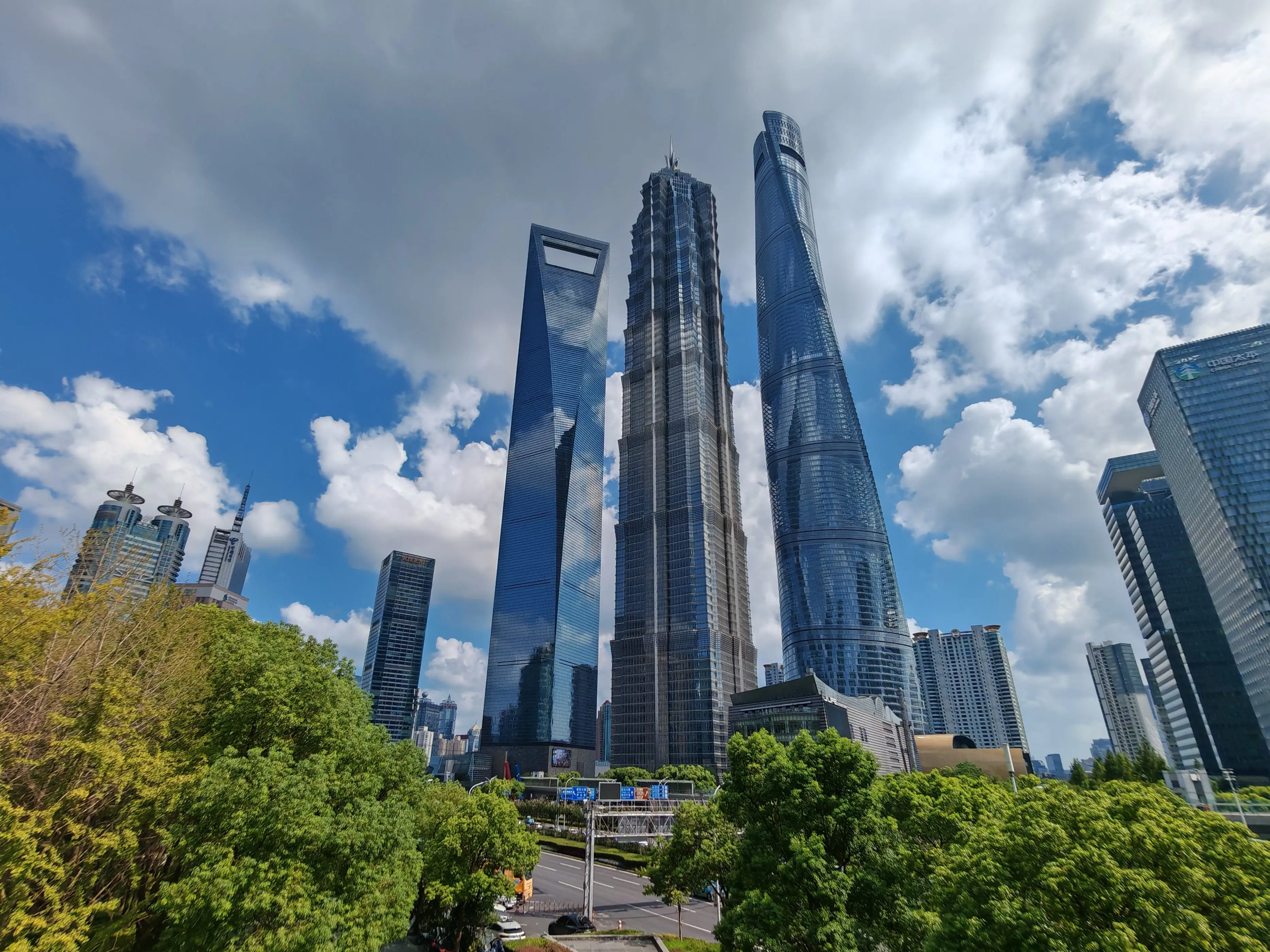 Three very tall buildings close together against a cloudy sky