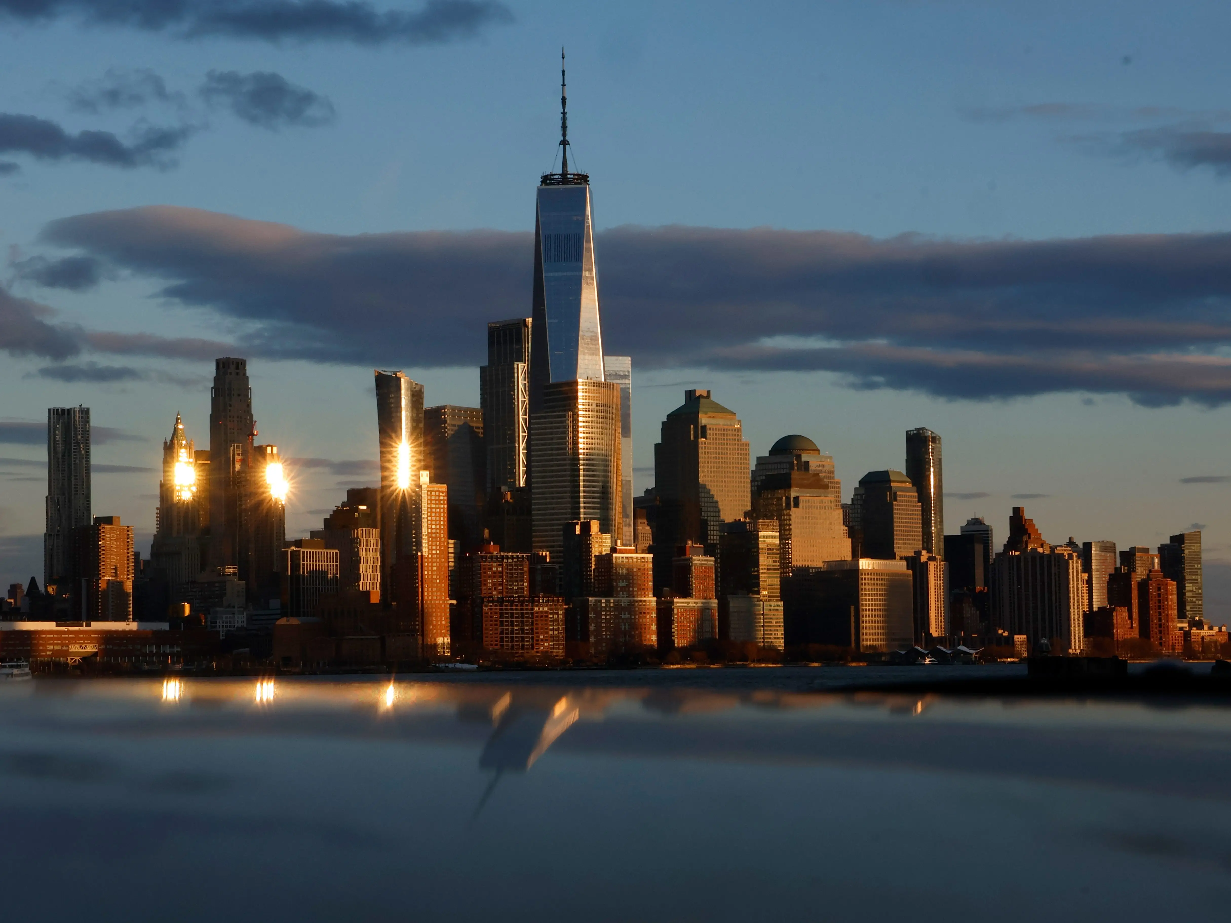 Several buildings in New York reflected in the water at susnet