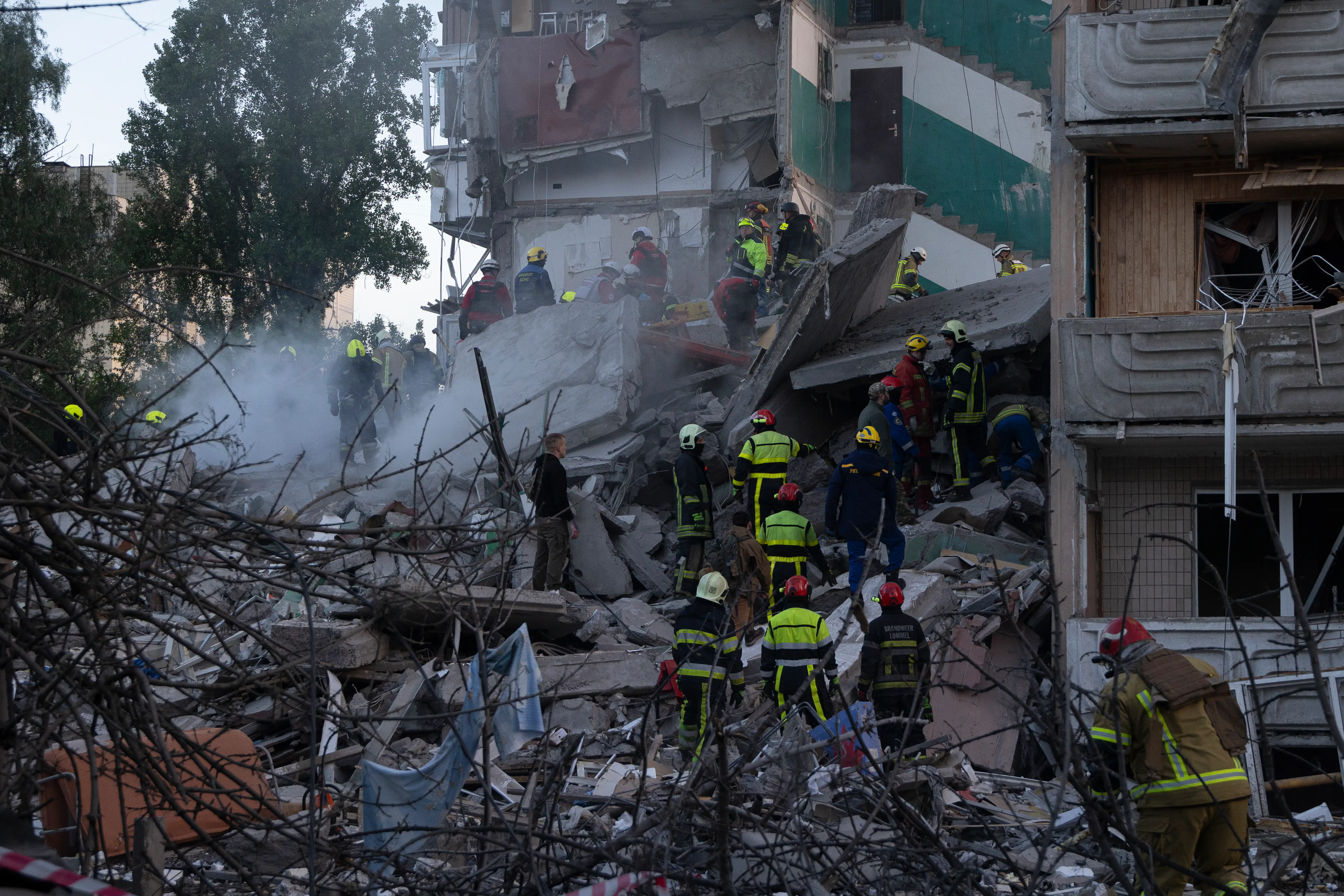 Rescue workers navigate debris of a collapsed building in Ukraine.