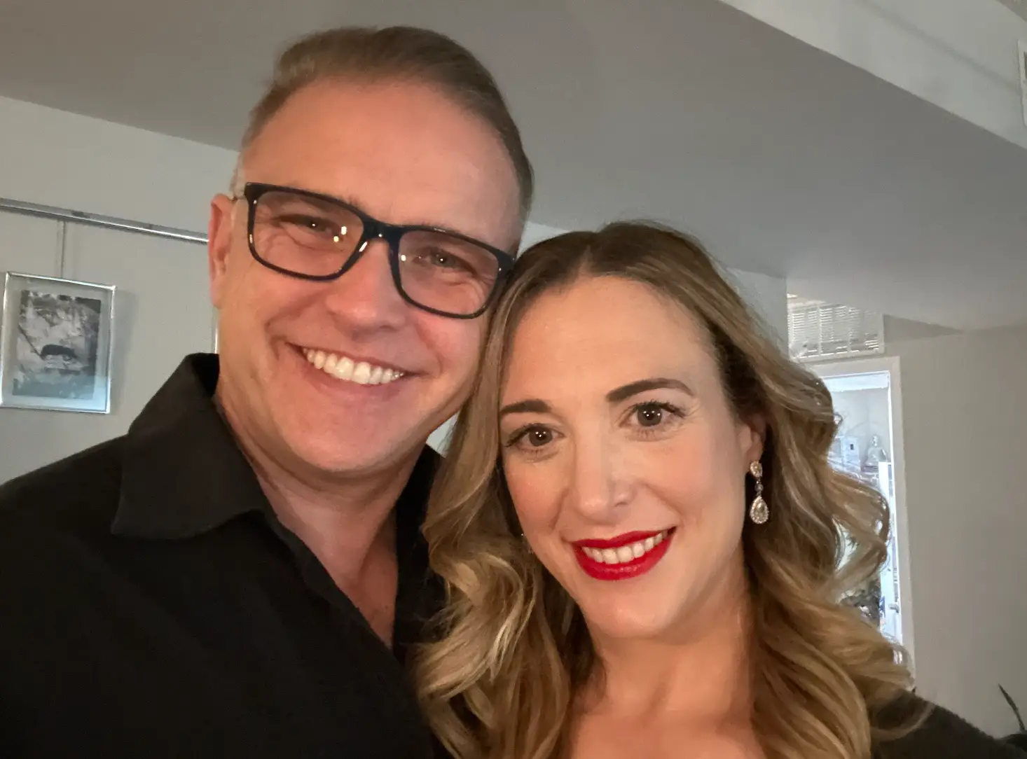 The writer and her husband, both dressed up and posing for close-up selfie.