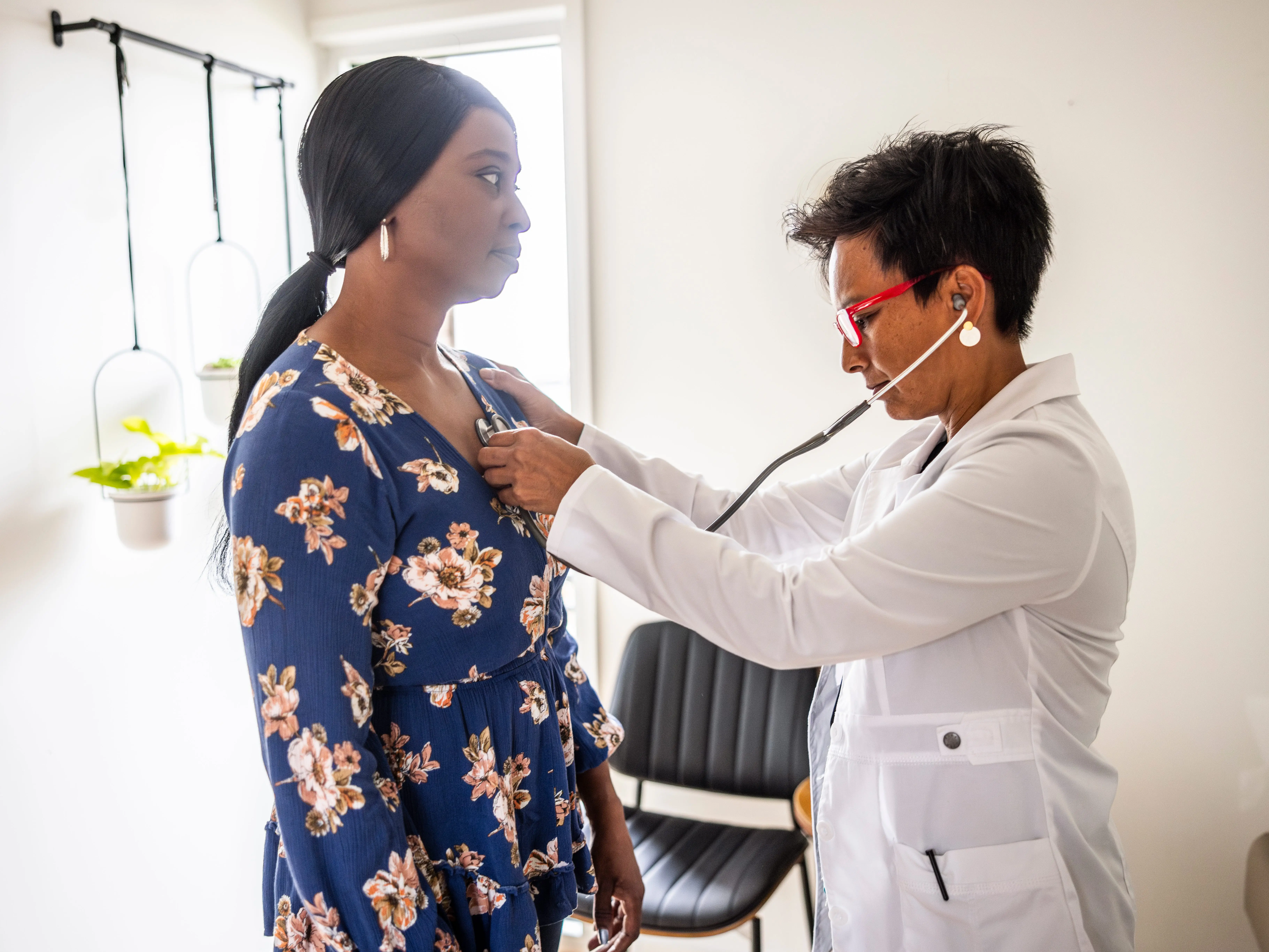 A doctor listening to a patient's heart with a stethoscope
