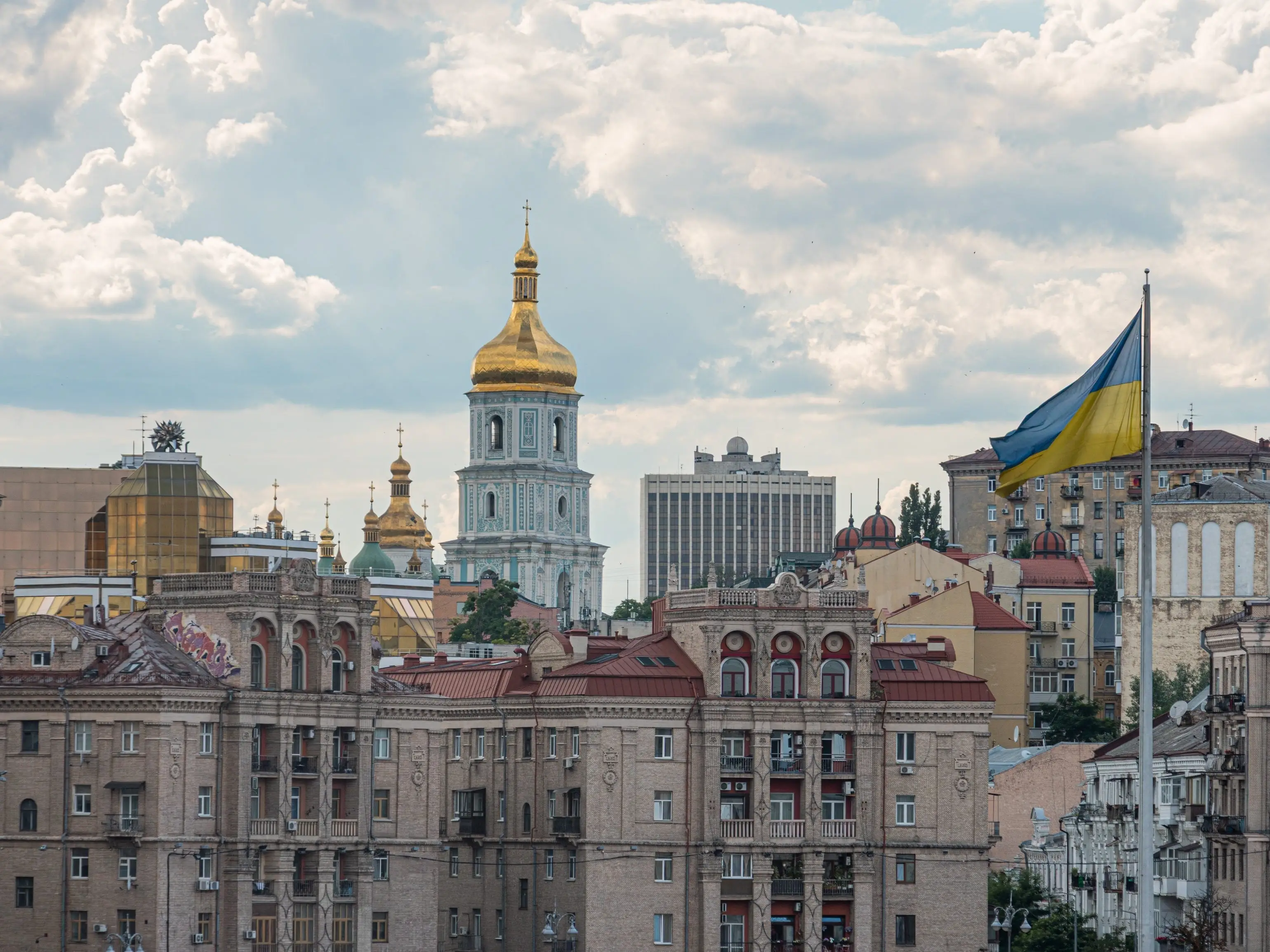 Buildings and Ukraine national flag in Kyiv, Ukraine.