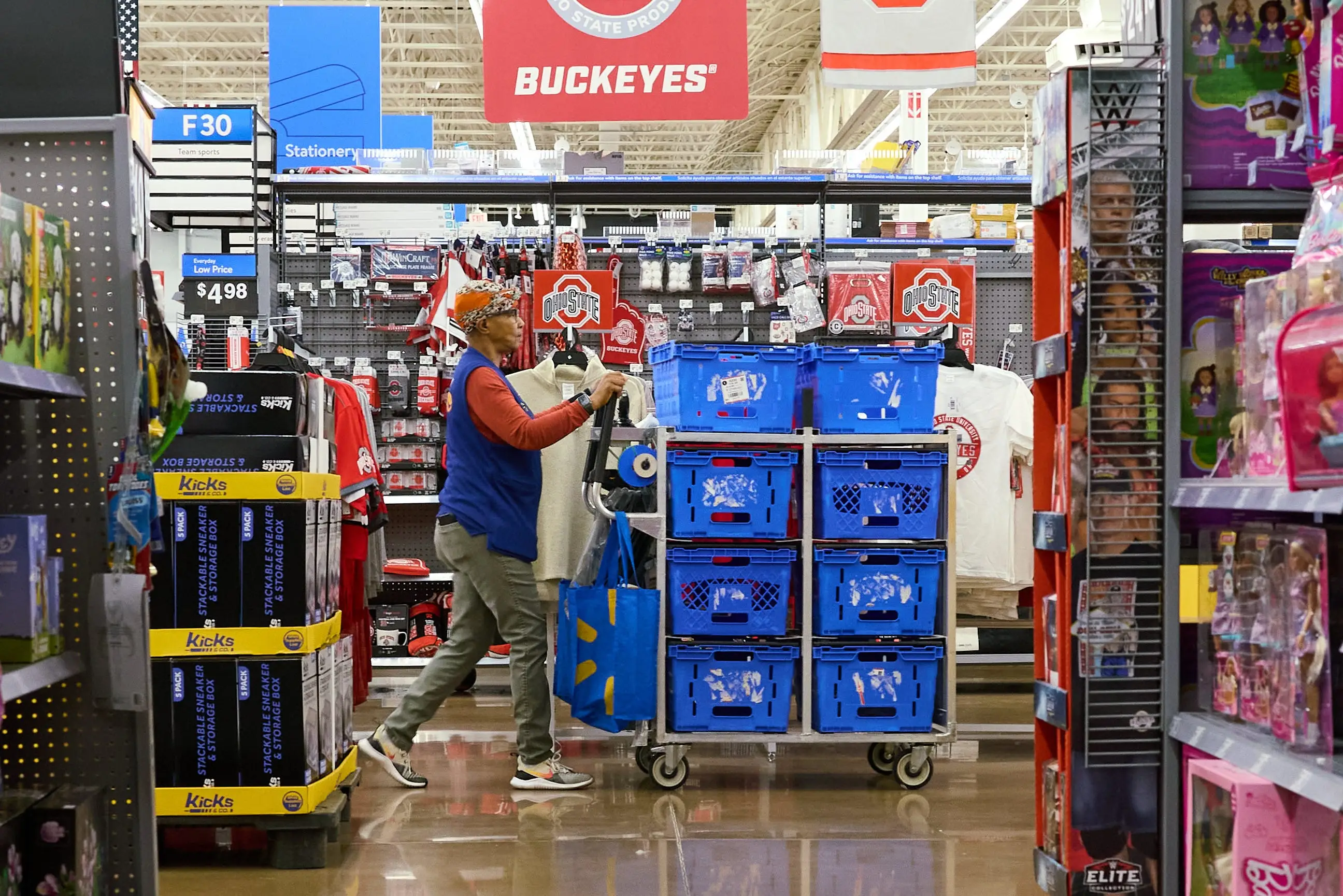 An associate pushes a cart filled with online orders at Walmart on Black Friday in Columbus, Ohio, US, on Friday, Nov. 28, 2025.