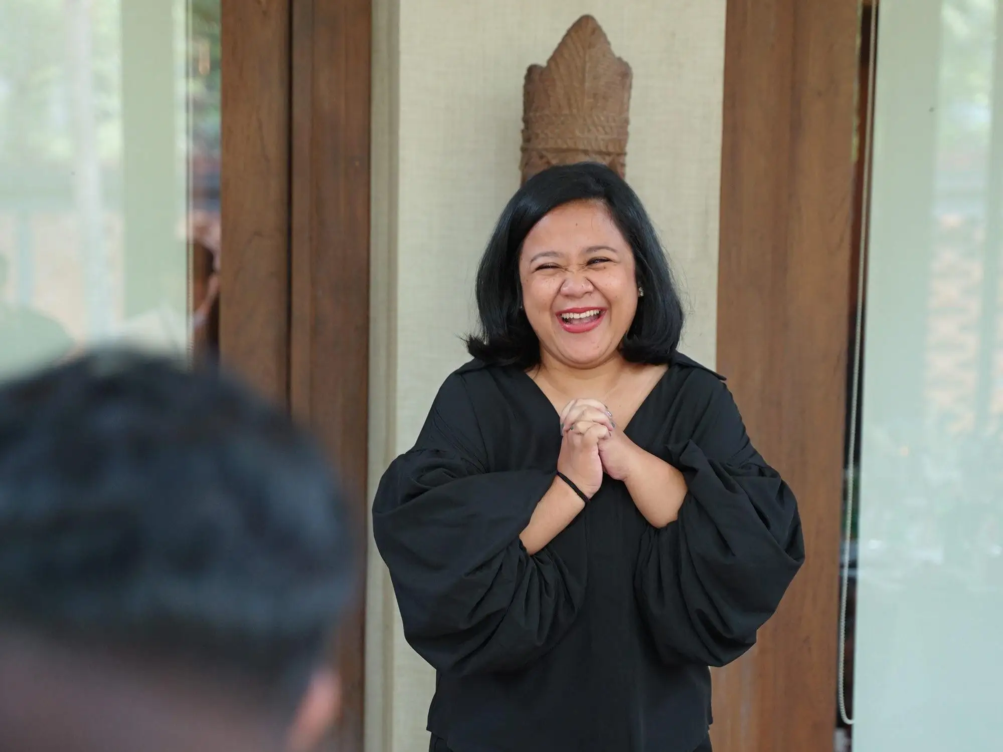 A woman standing and dressed in black.