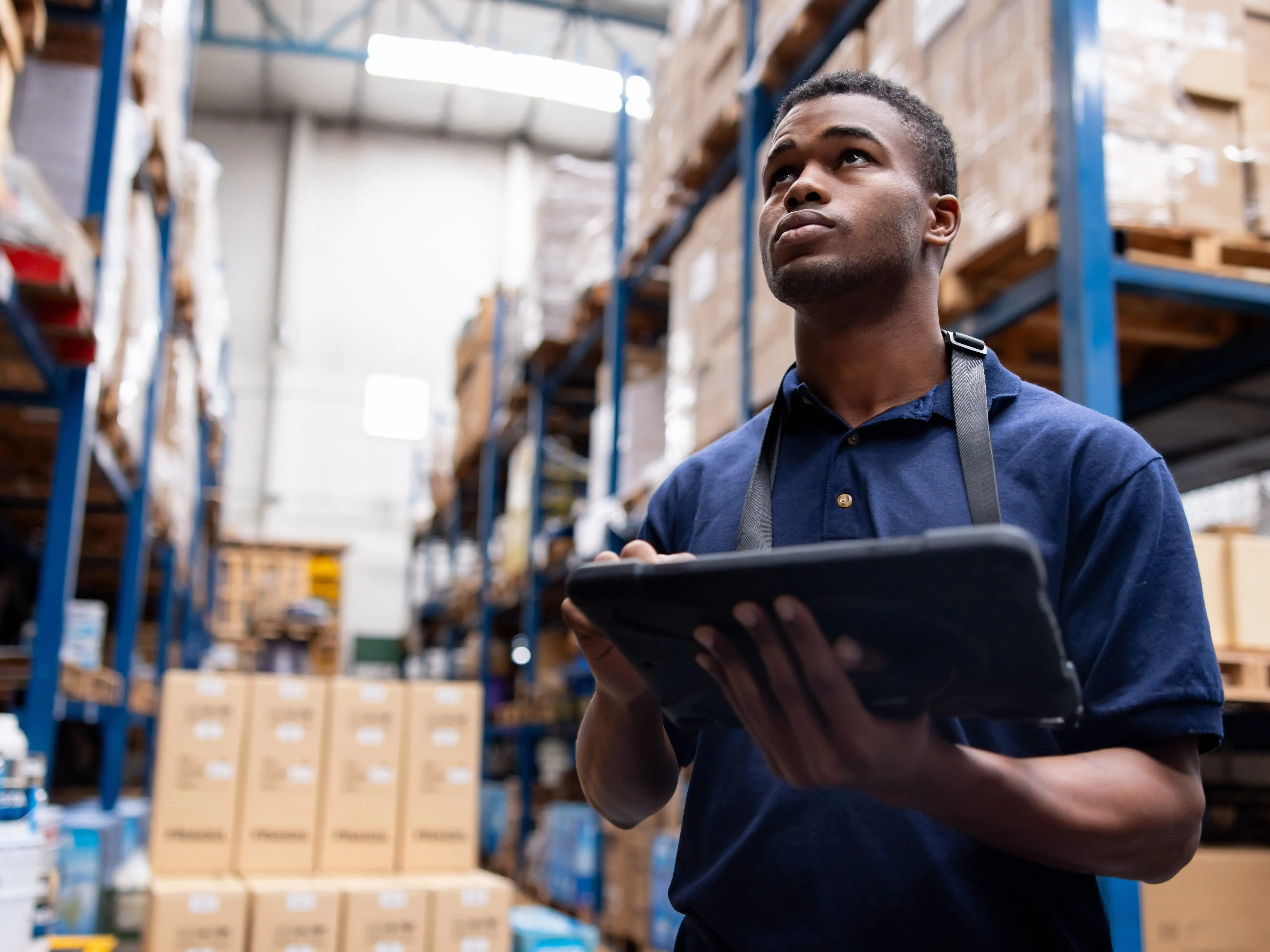 A person at a warehouse is holding a tablet