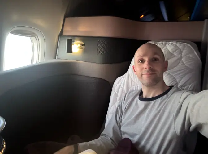 Man taking selfie in Qatar Airways business-class suite