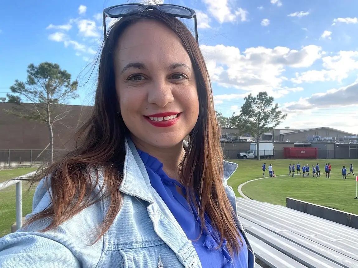 The author is sitting in the bleachers at a youth sports event.