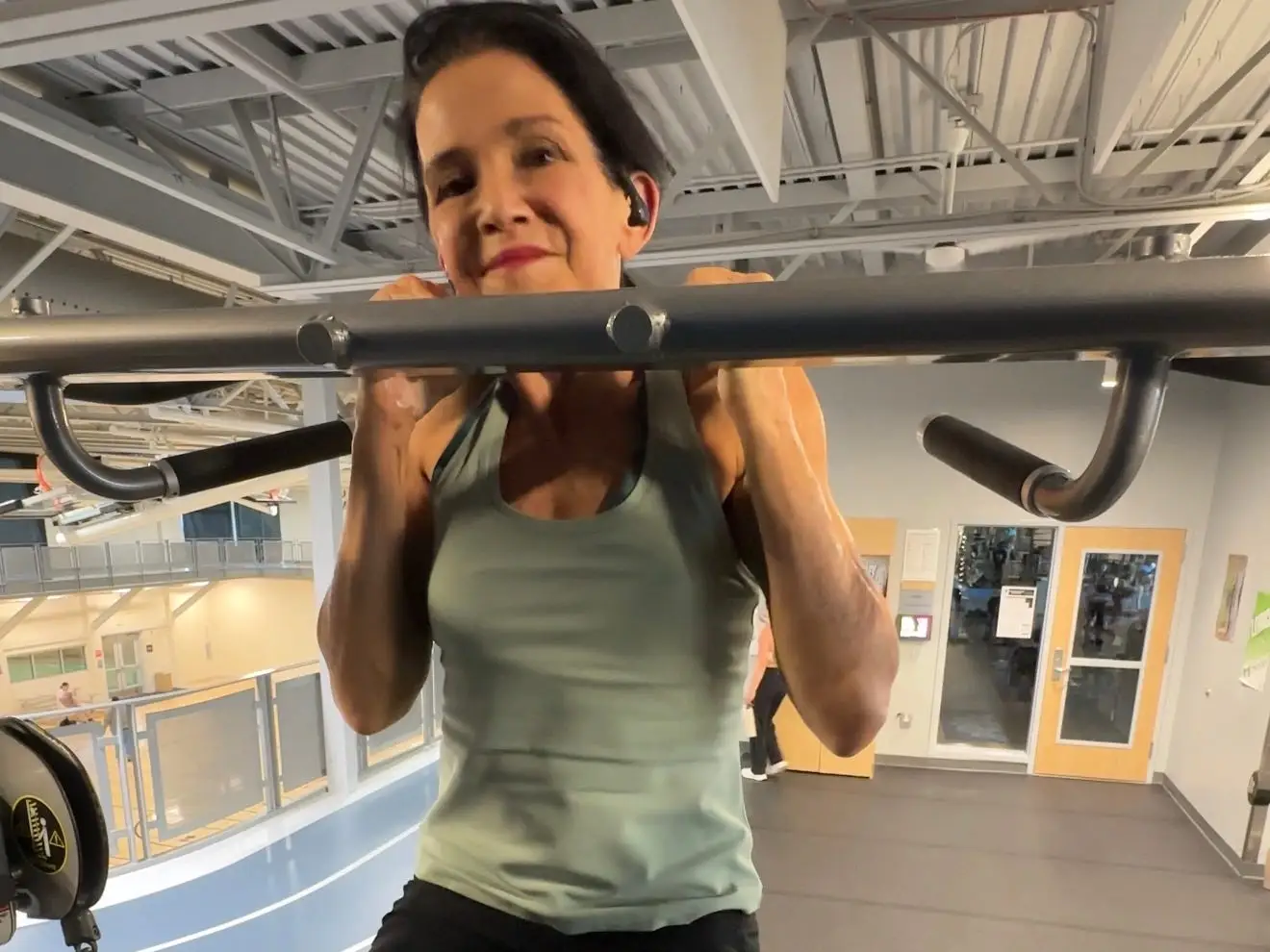 An older woman working out on a monkey bar