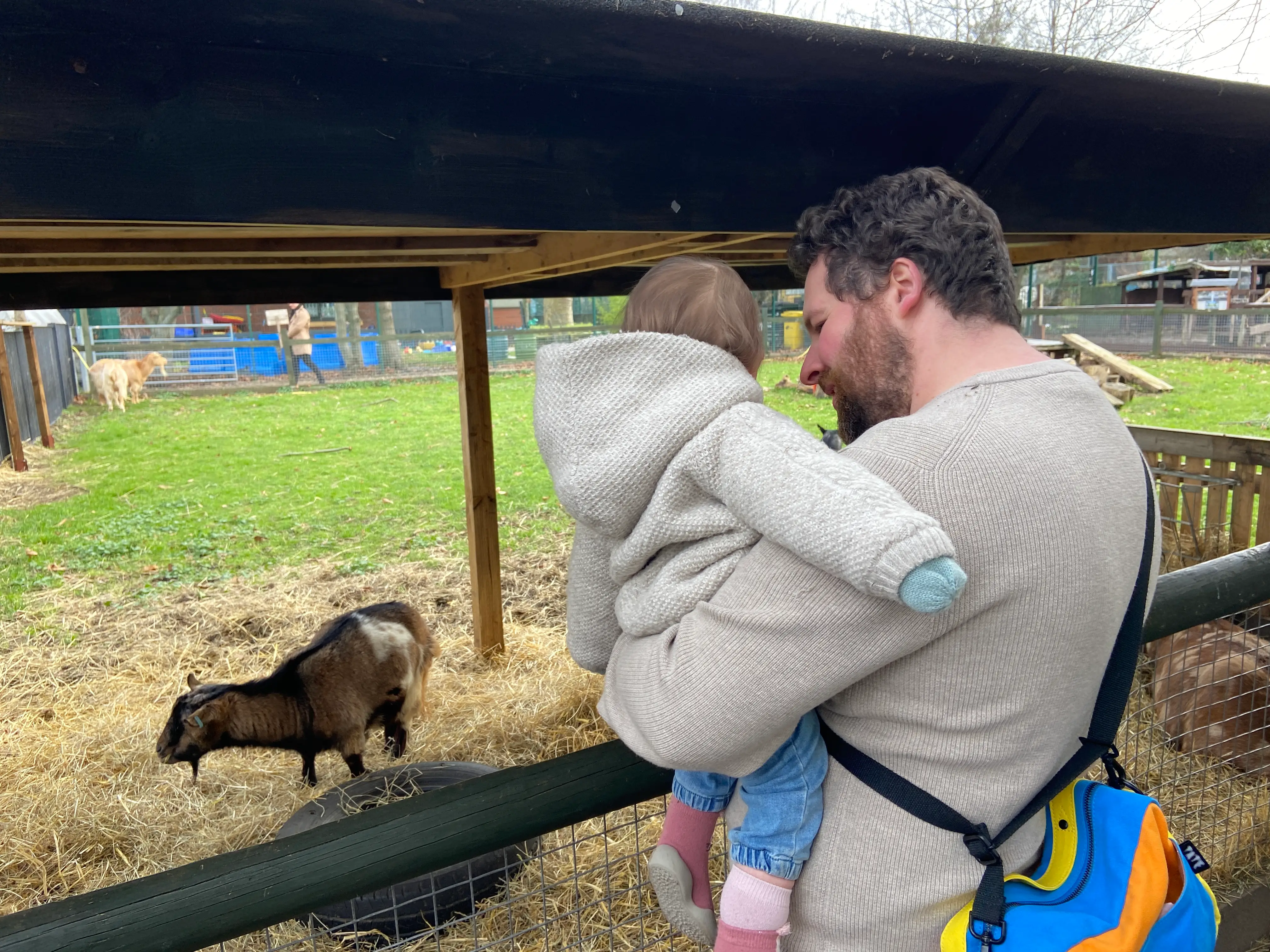 the author's husband holding their daughter at the Spitalfields City Farm in London