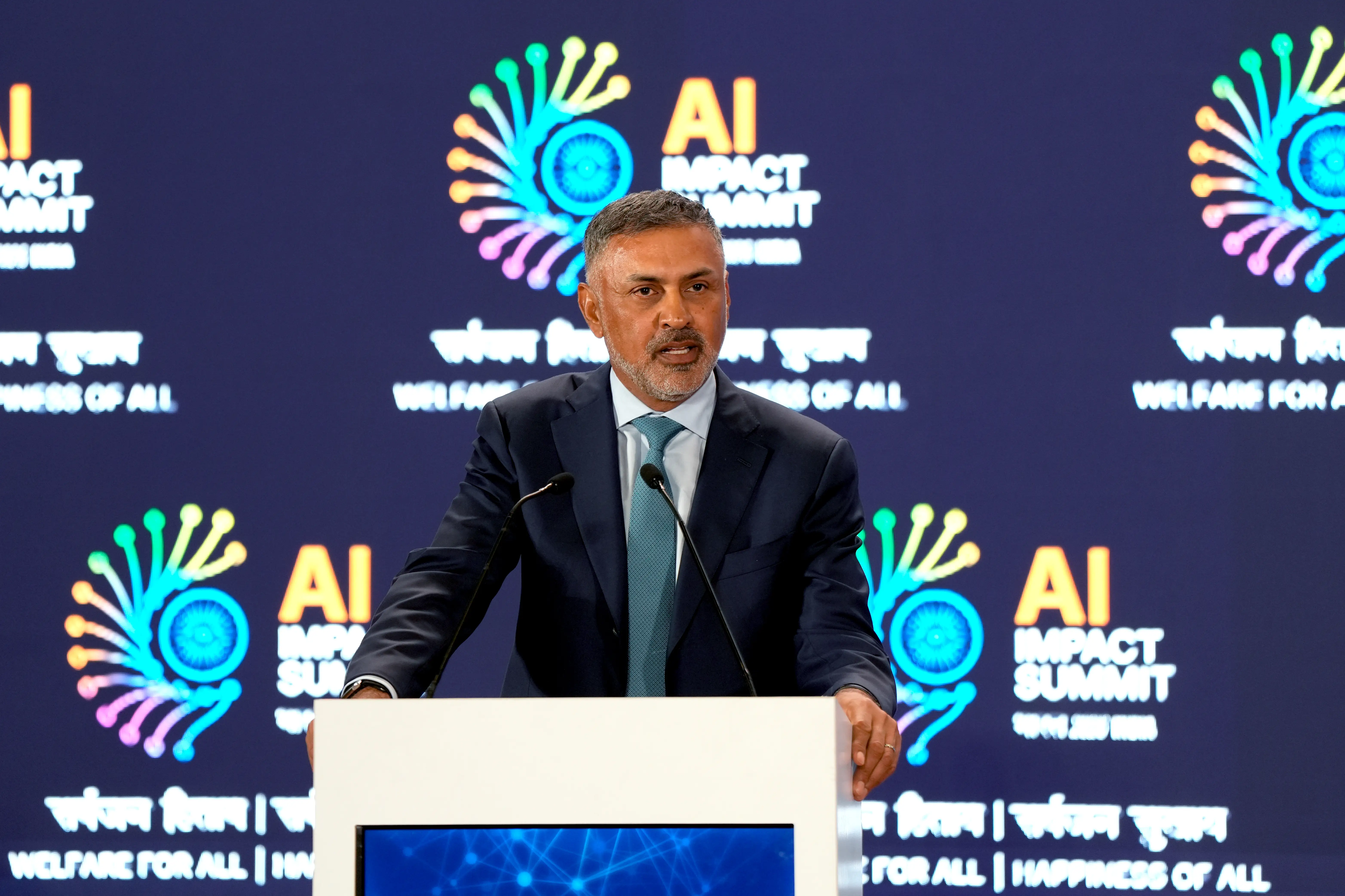 Nikesh Arora talks into a mic at a lectern.