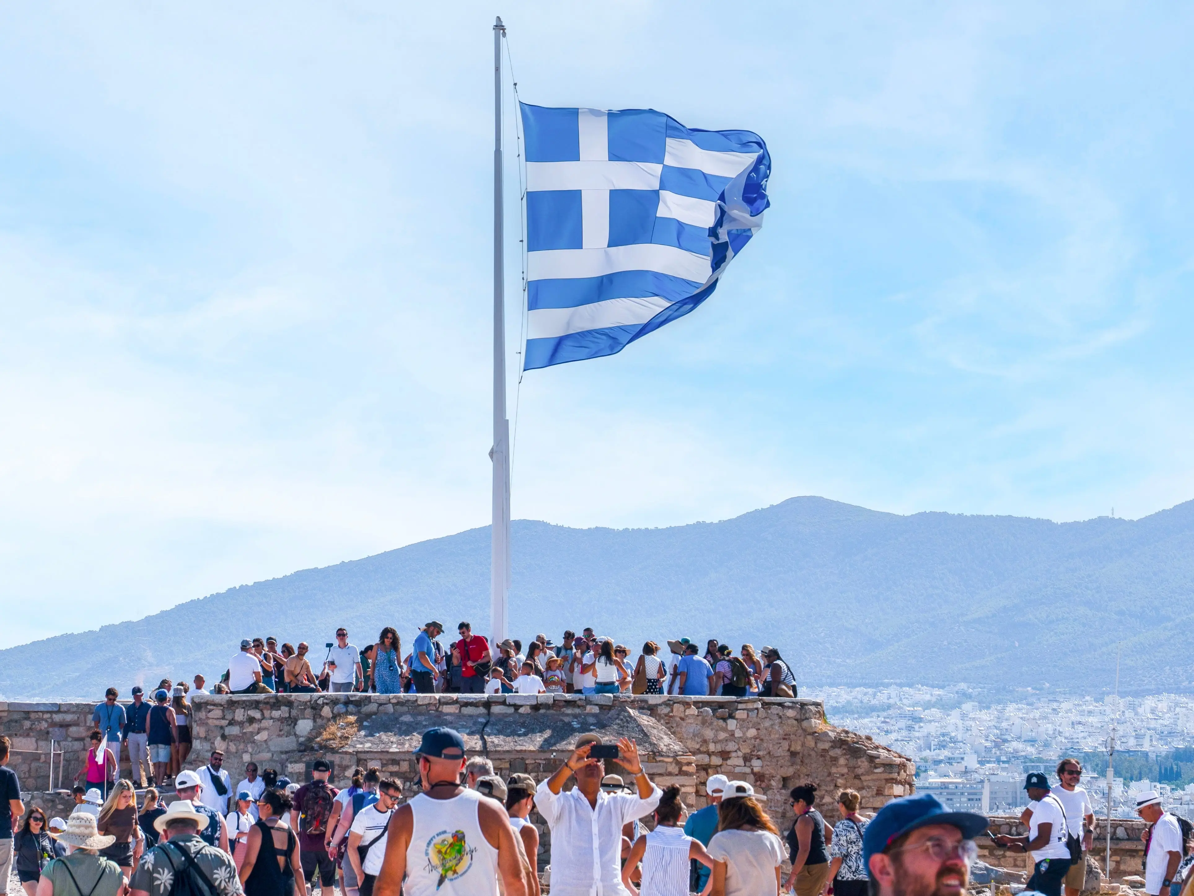 National flag and crowd of people in Athens, Greece.
