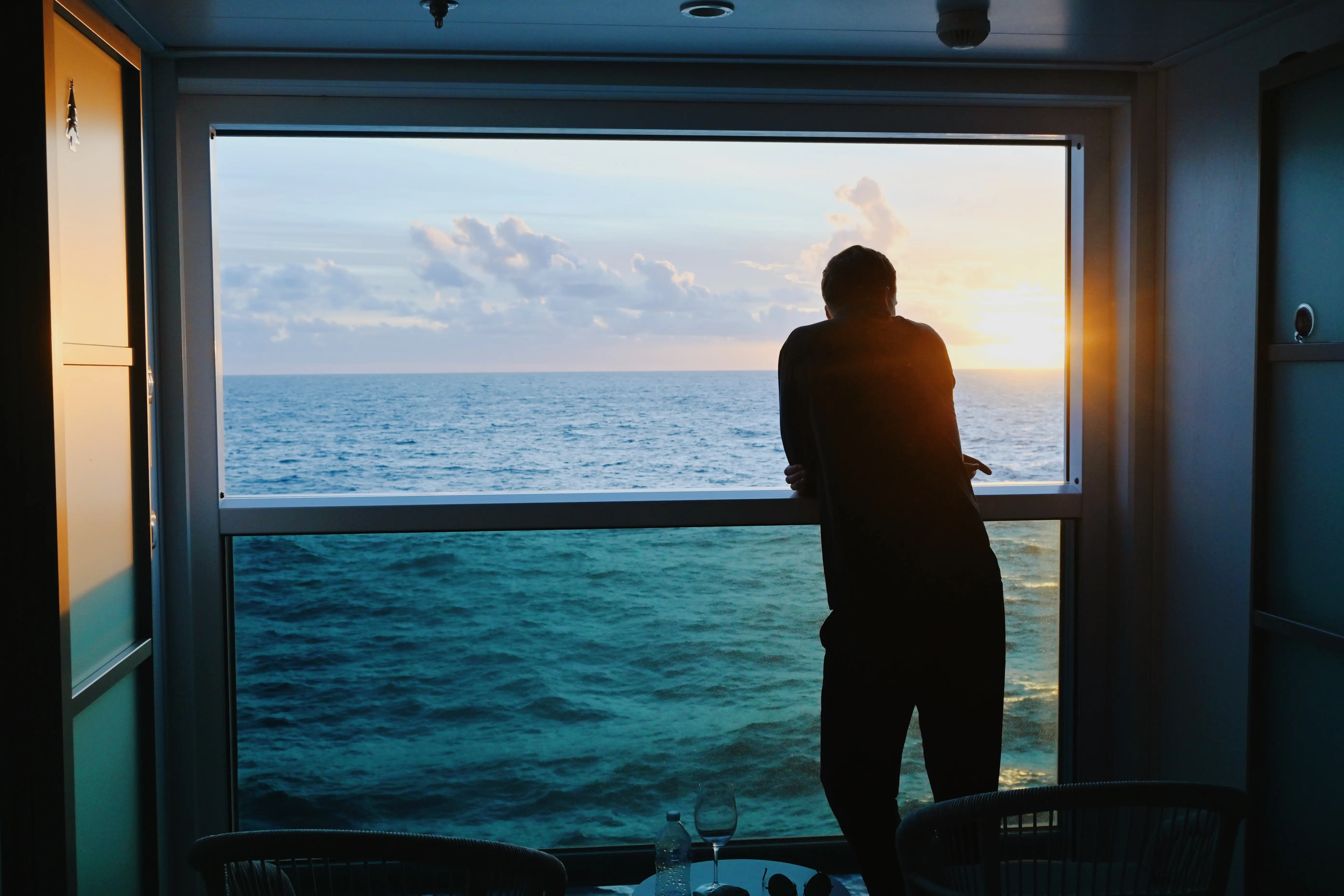 Man leaning over window ledge in Infinite Veranda cabin on Celebrity cruise