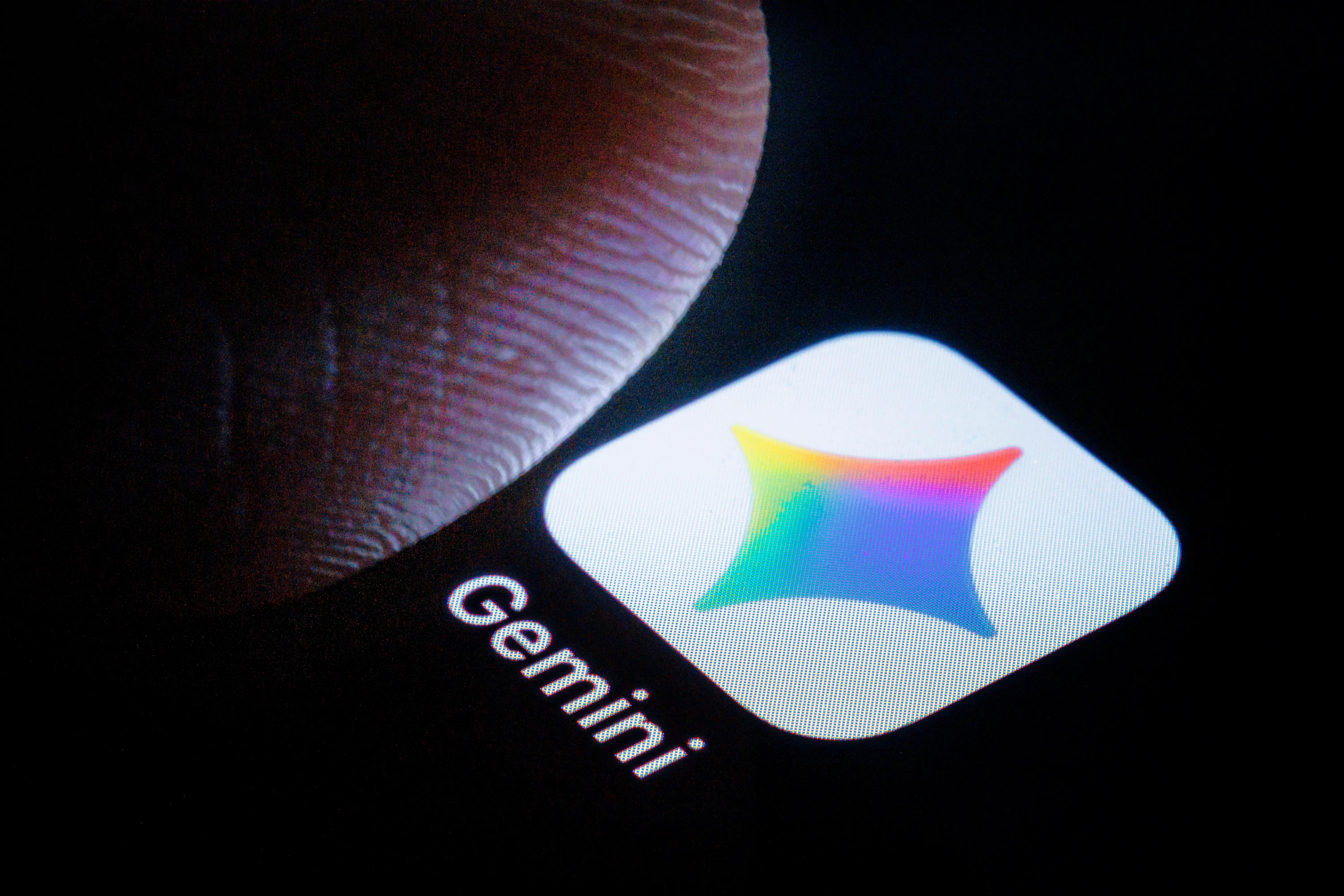 BERLIN, GERMANY - MARCH 06: In this photo illustration the logo of Google Gemini can be seen next to a finger on a smartphone on March 06, 2026 in Berlin, Germany. (Photo by Thomas Trutschel/Photothek via Getty Images)