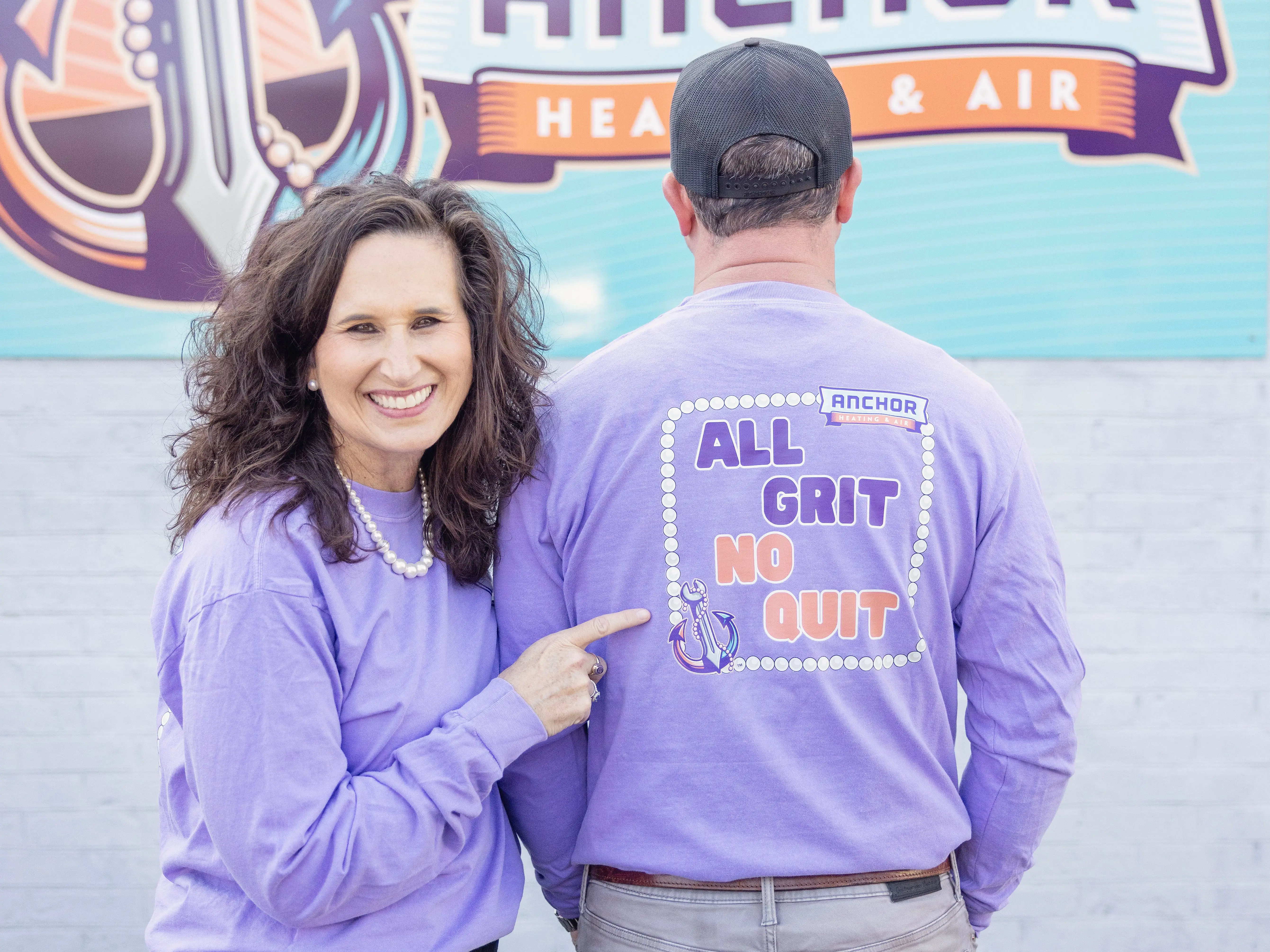 A couple wearing purple shirts.