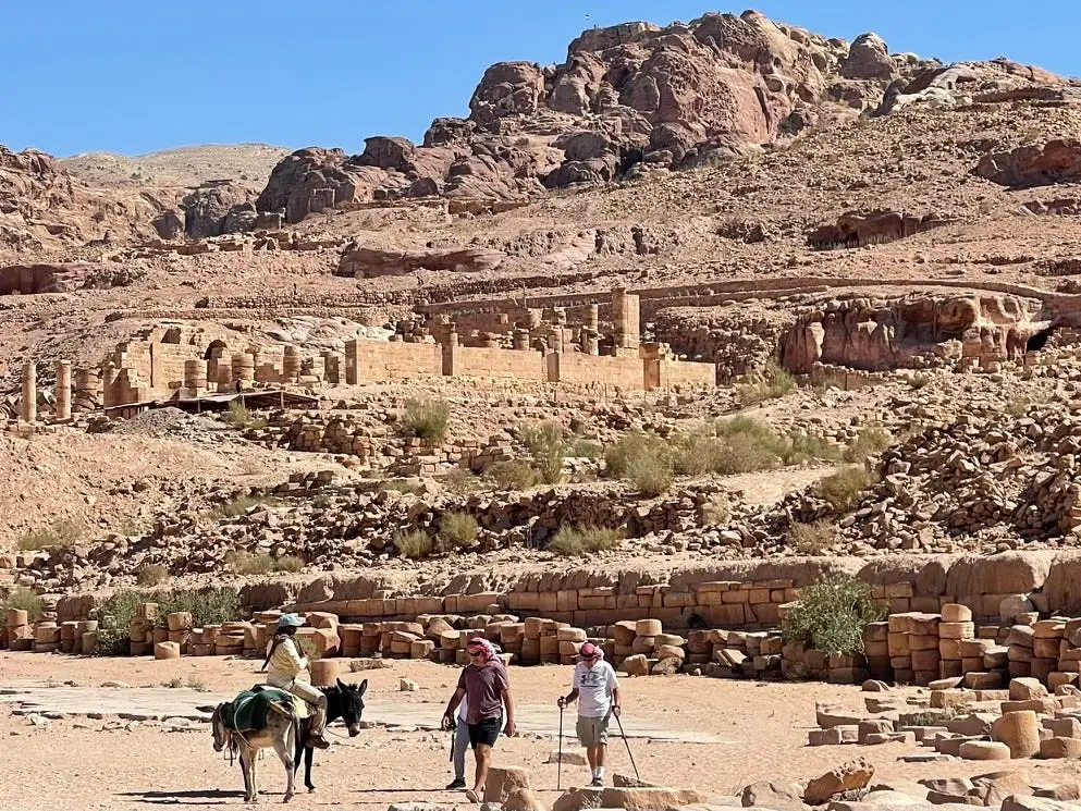 Several people exploring the rocky and uneven terrain in Petra, Jordan.