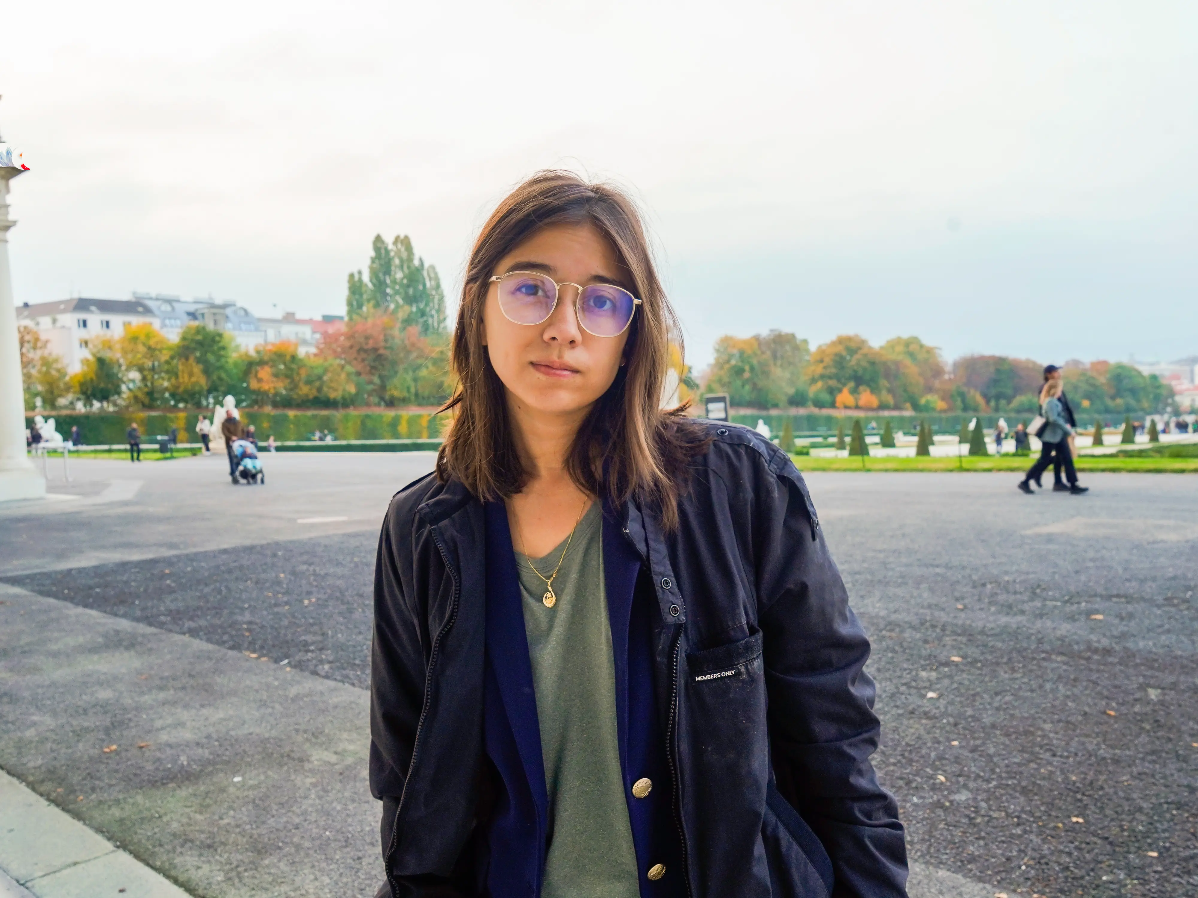 The author stands in front of a garden in Vienna