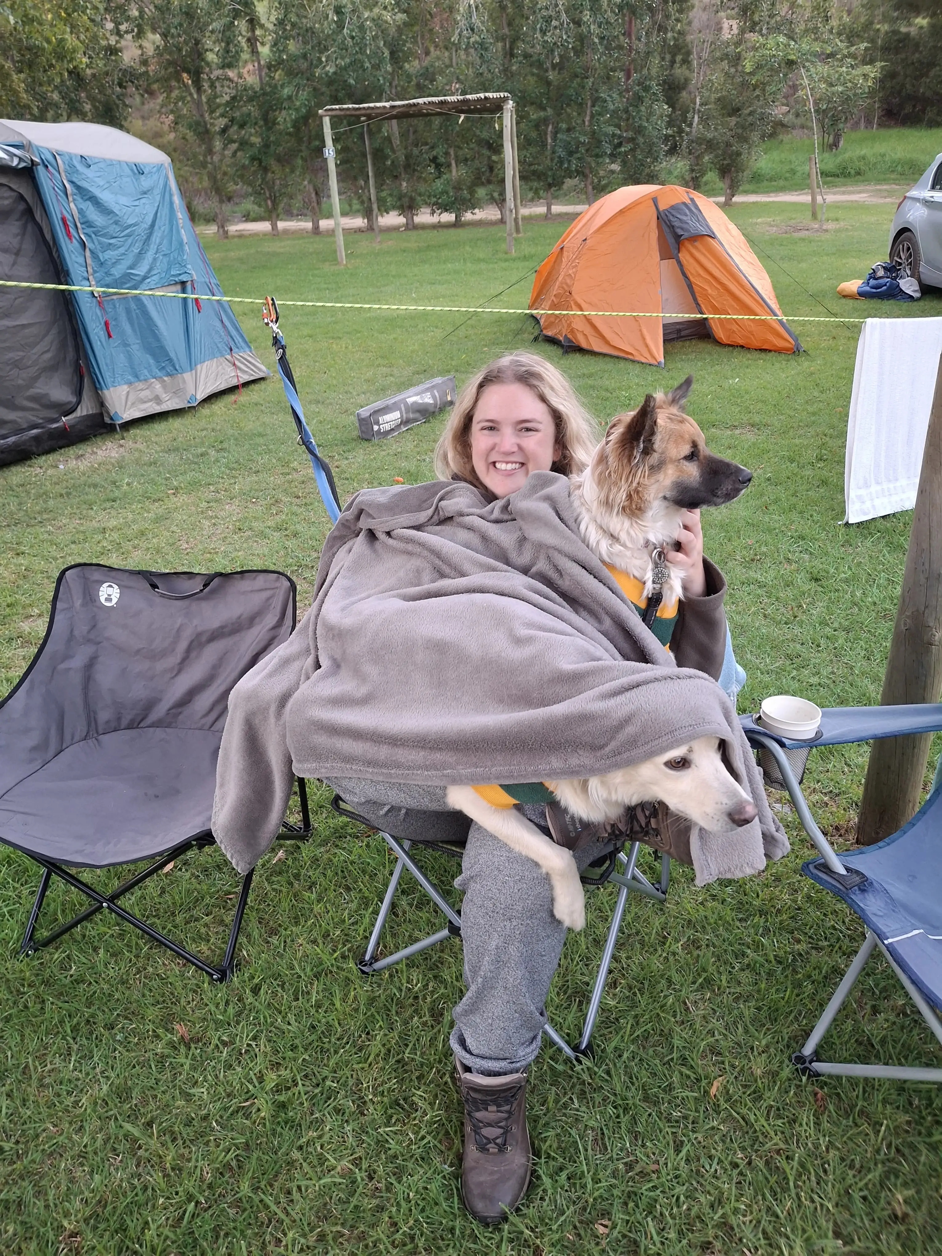 The author sitting on a camping chair with two dogs.