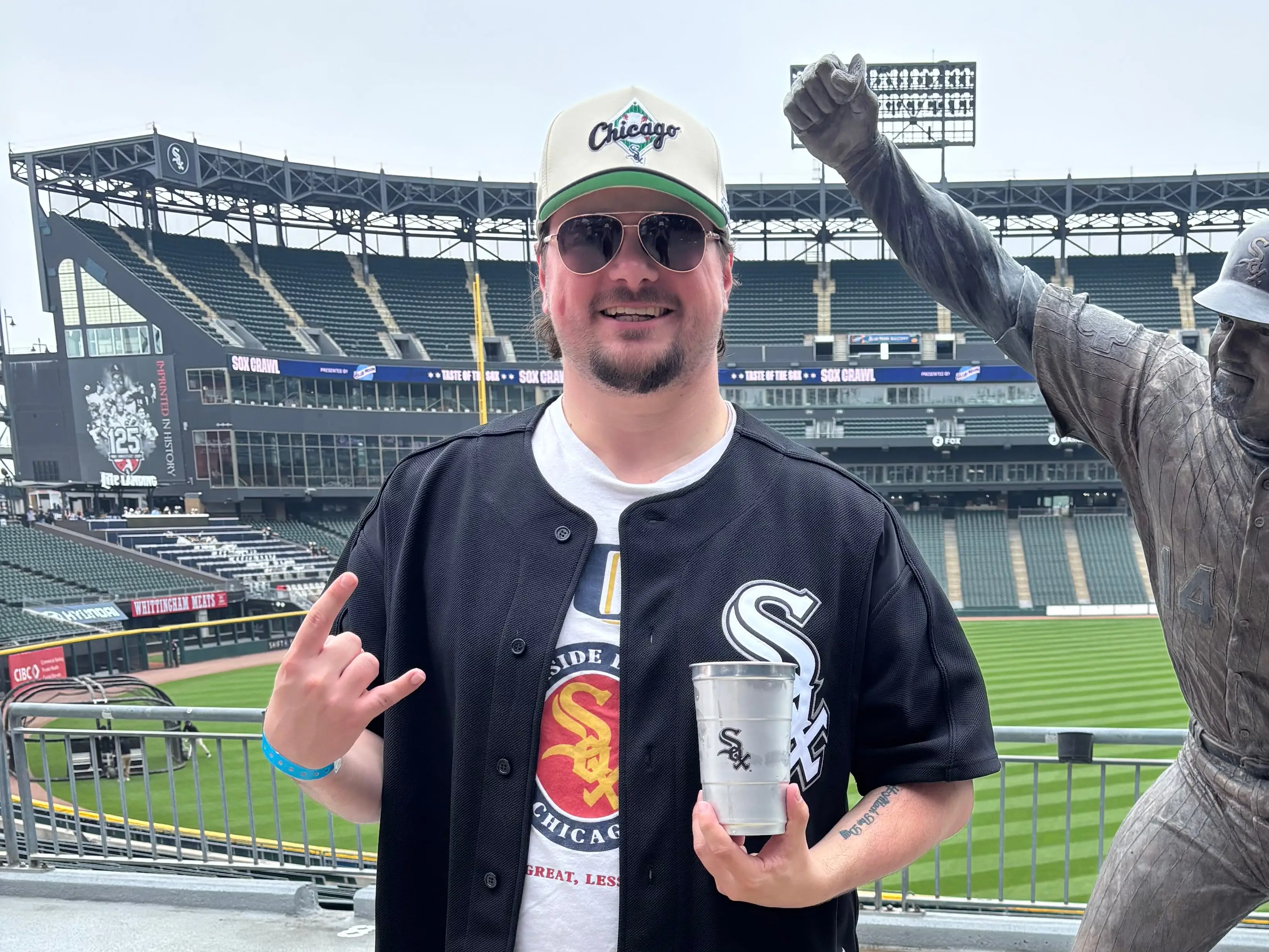 a man poses at a baseball game