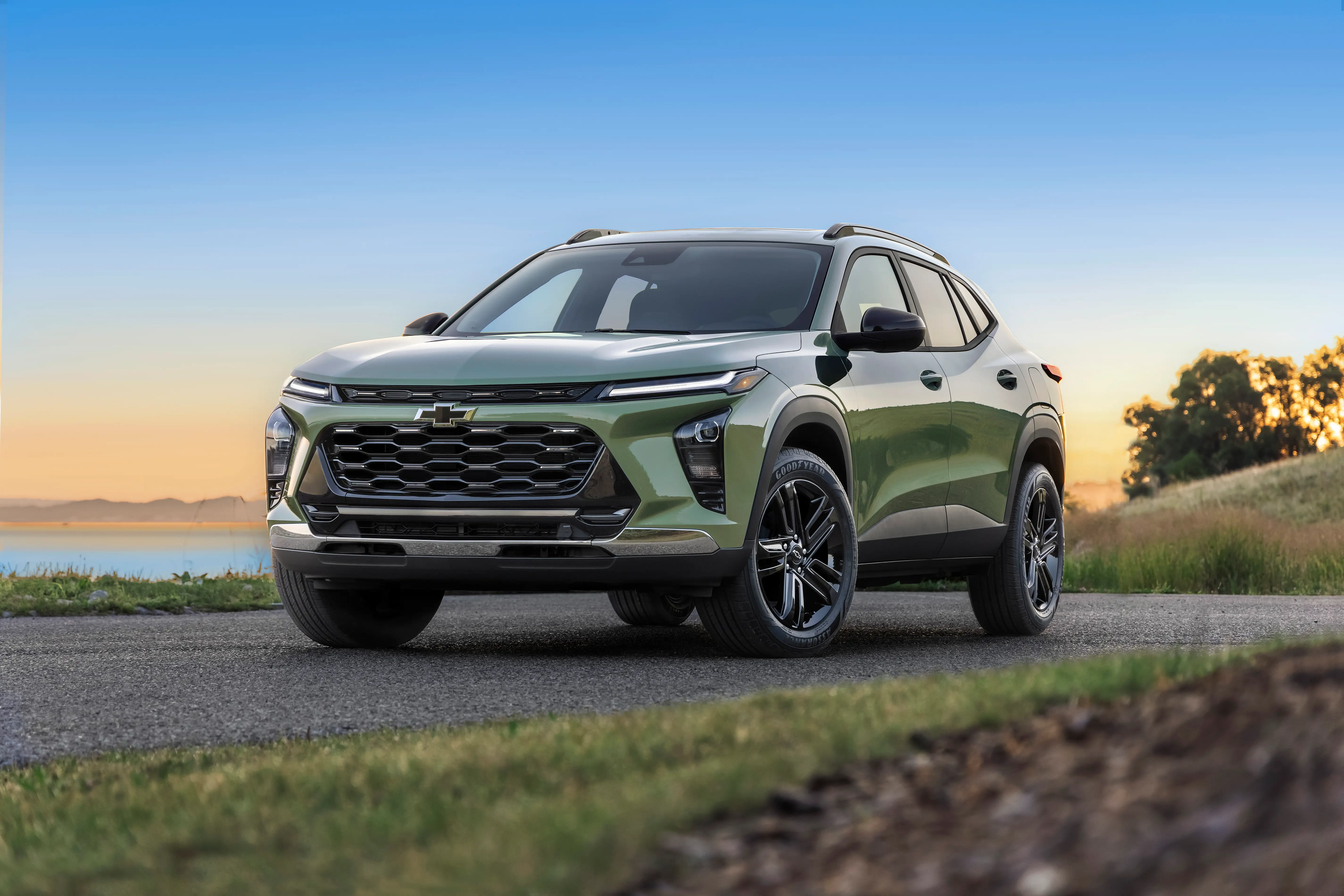 A light green Chevy Trax is parked on a patch of pavement.