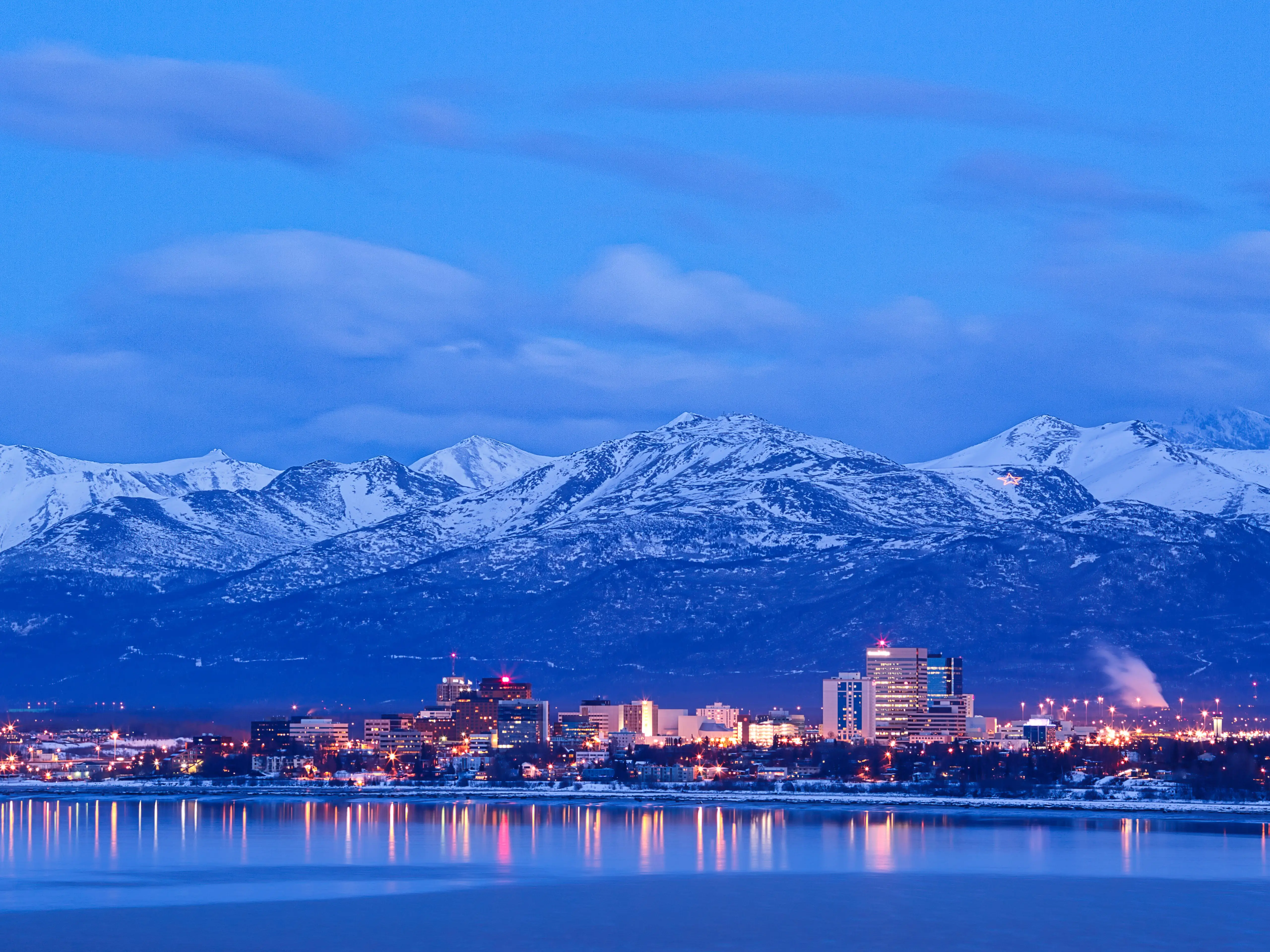 Anchorage Alaska skyline in winter at dusk with the Chugach mountains behind.