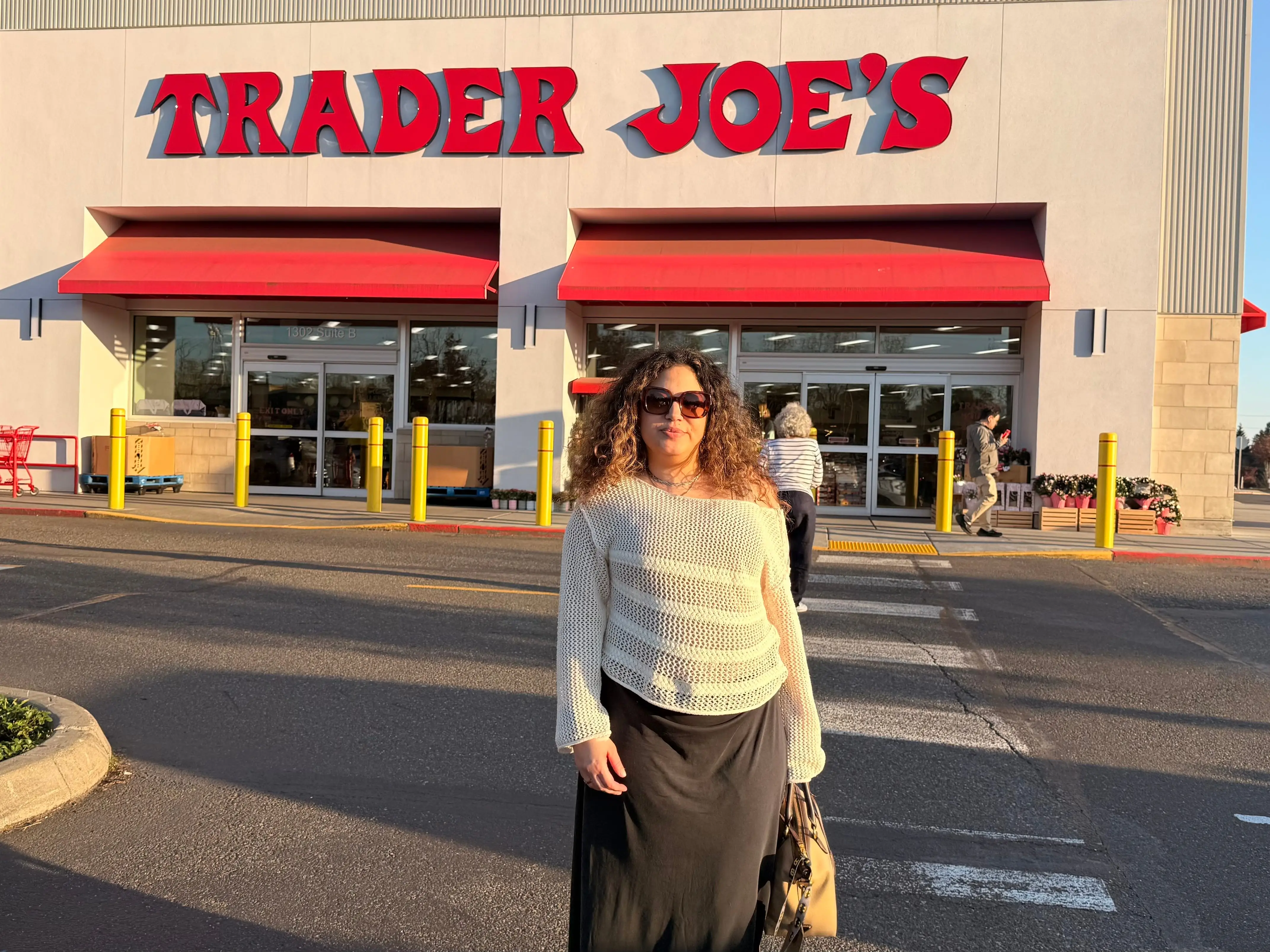 A woman standing outside a Trader Joe's.
