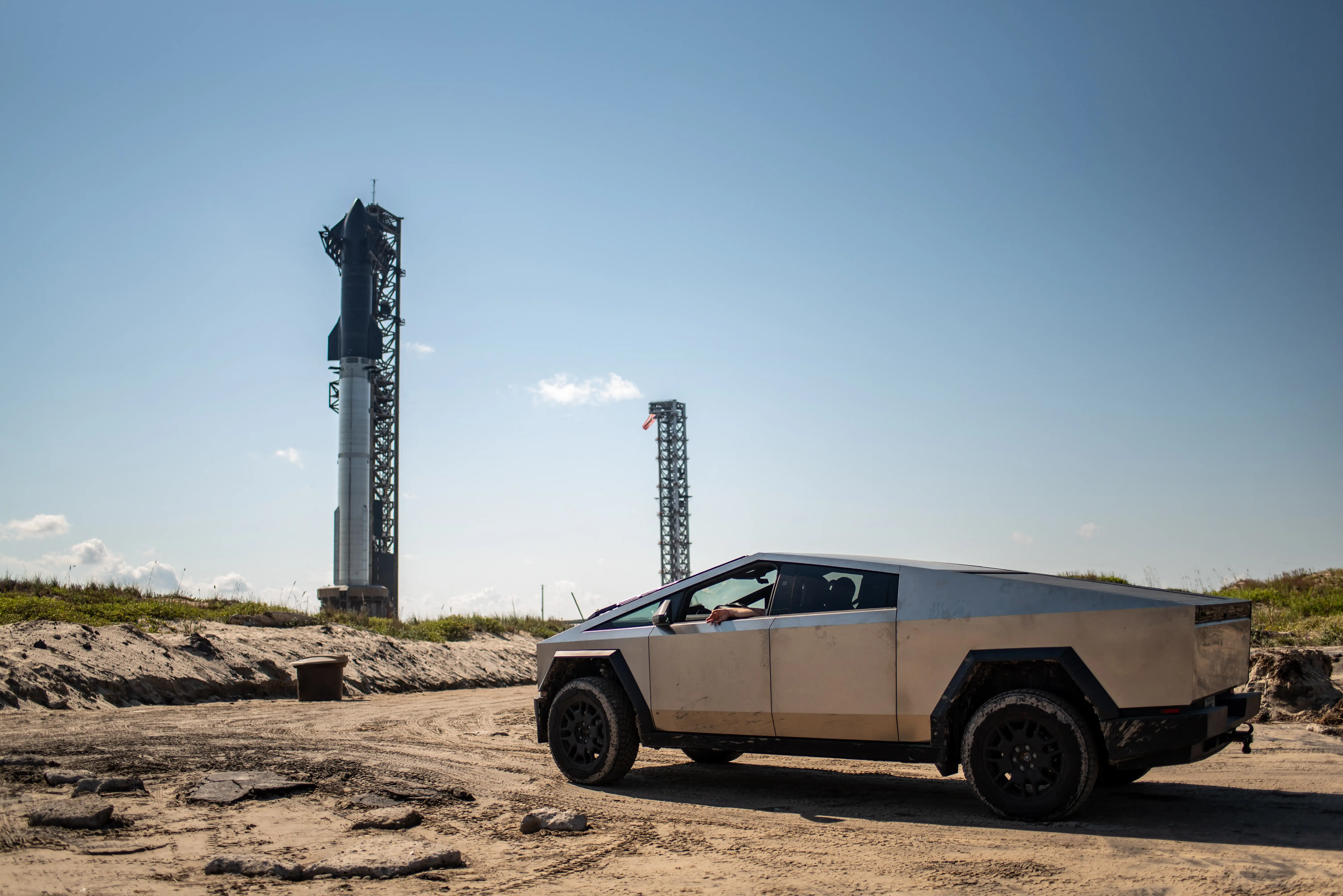 A driver sits inside a Tesla Cybertruck near a SpaceX launch site.