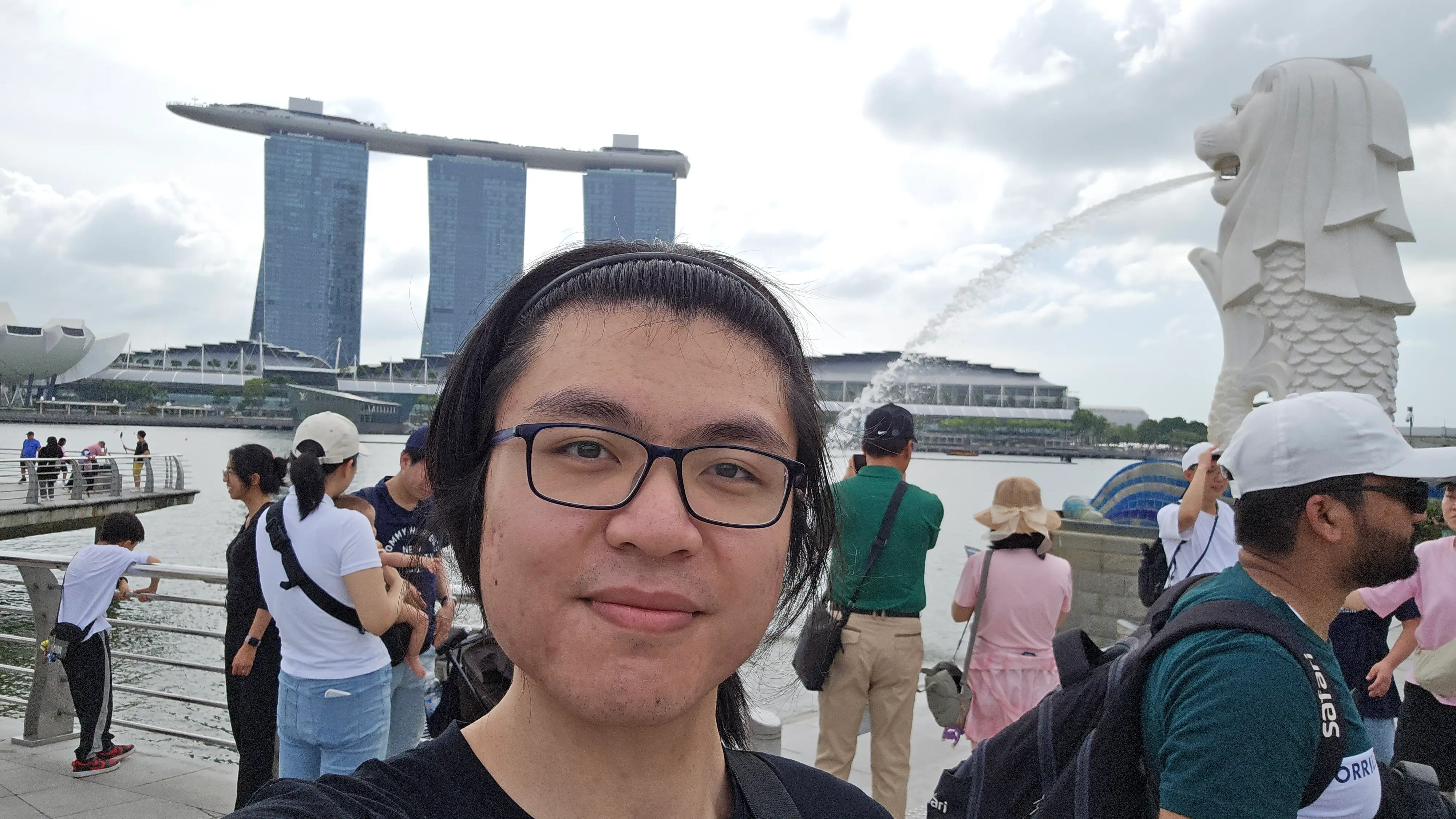 Raymond Zeng outside with a fountain and river in the background.