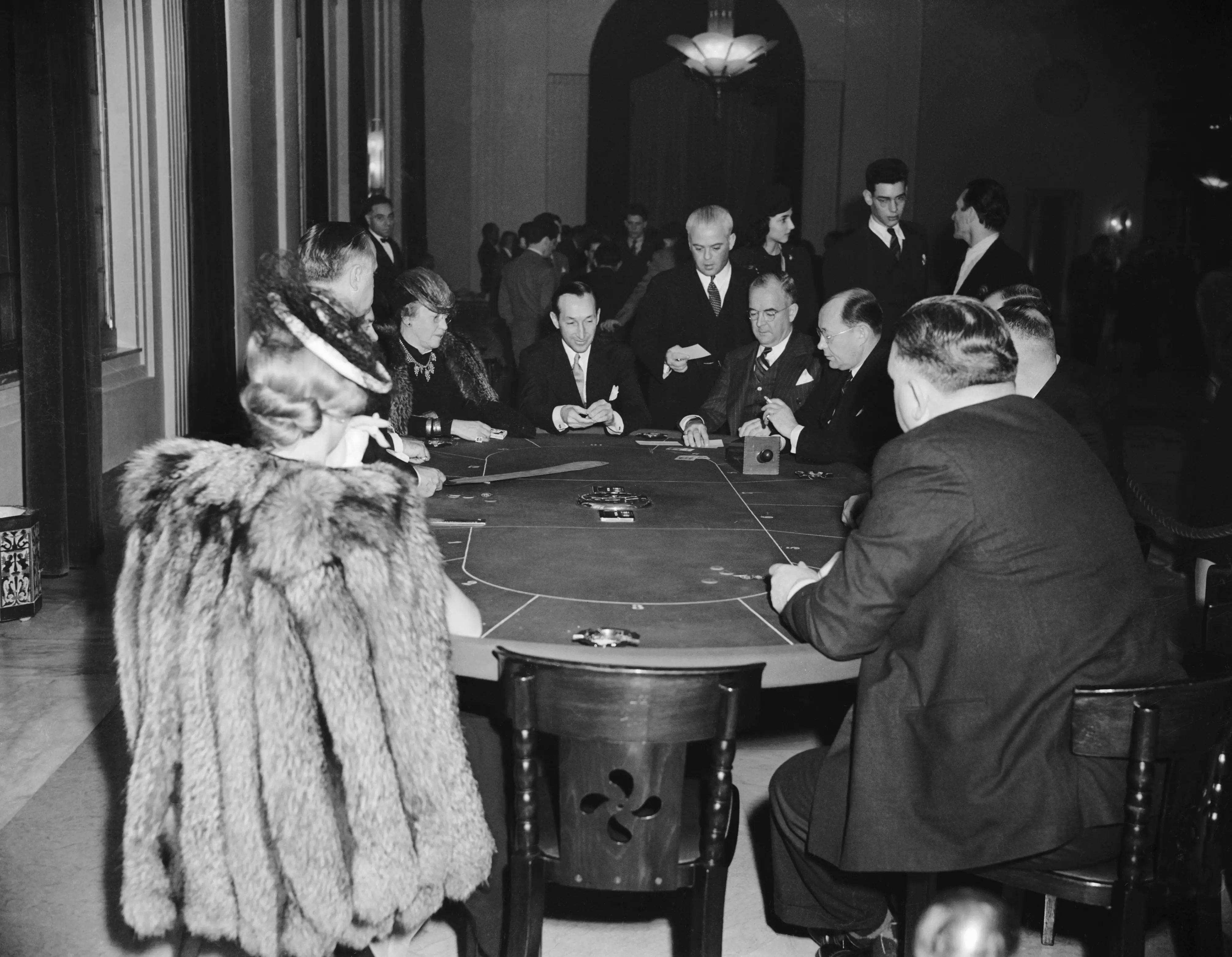 In Havana, Cuba, 1940, elegantly-dressed men and women play a hand of cards at a casino.