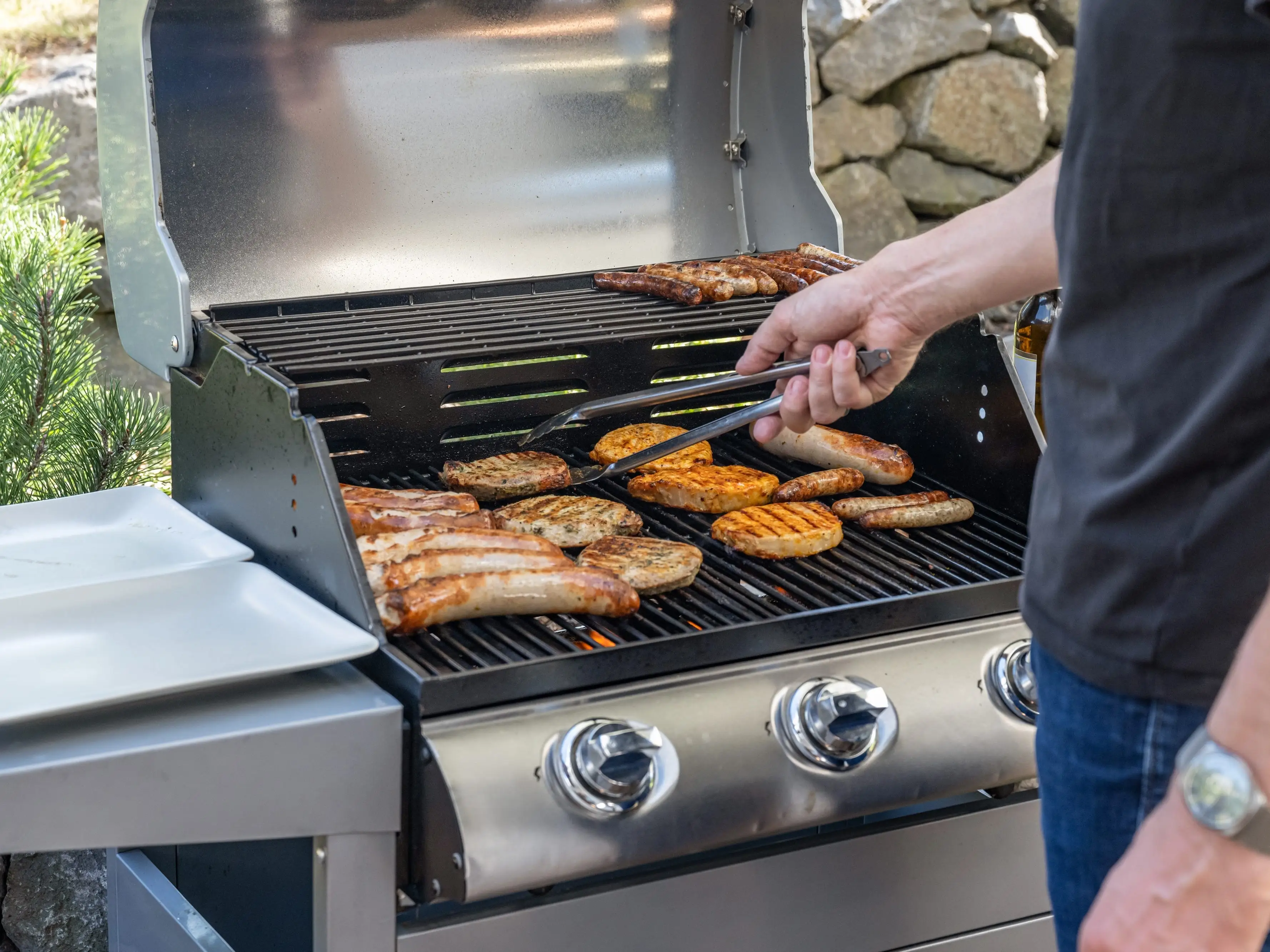 Person grilling meat on grill