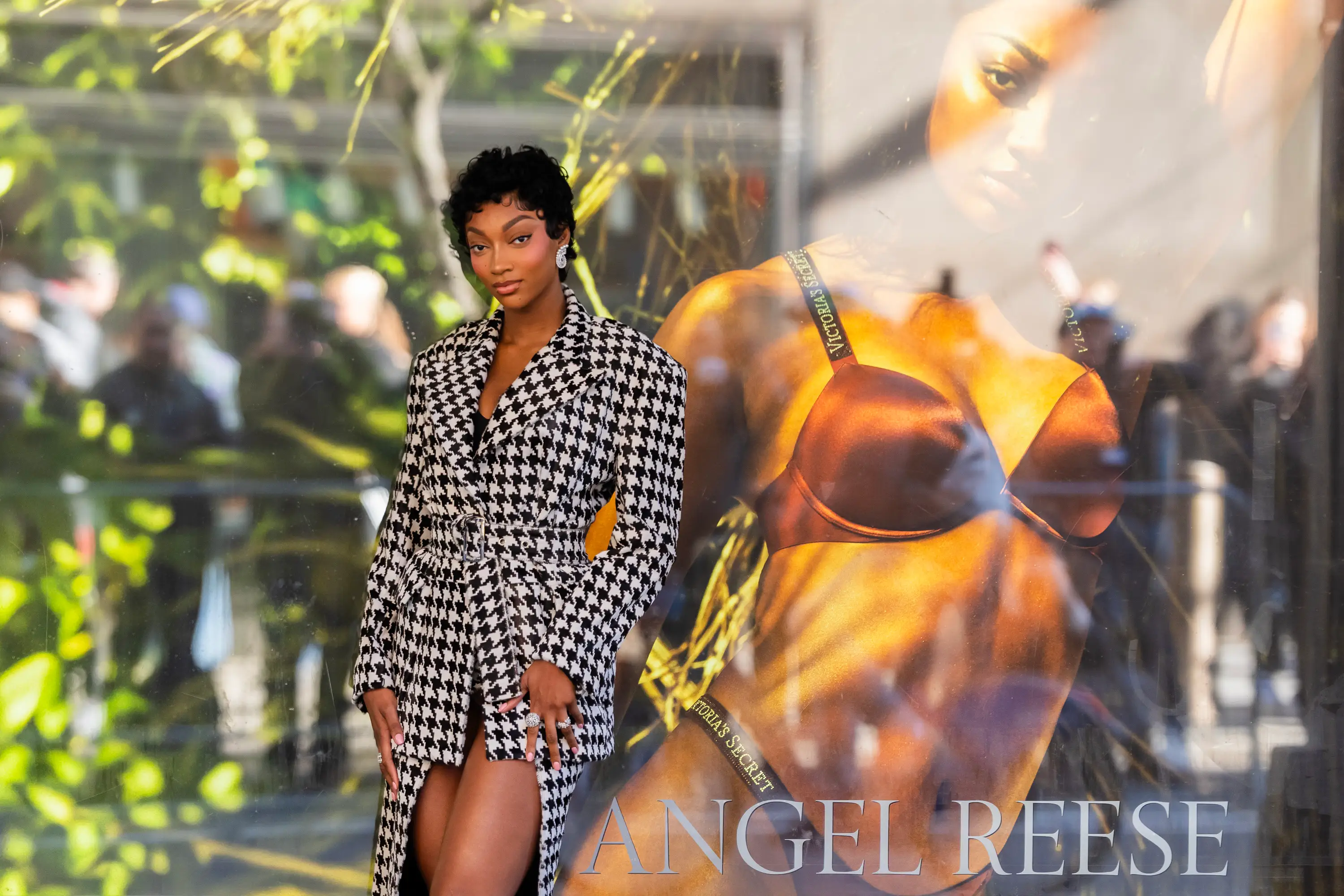 Angel Reese stands in front of her photo outside a Victoria's Secret store.