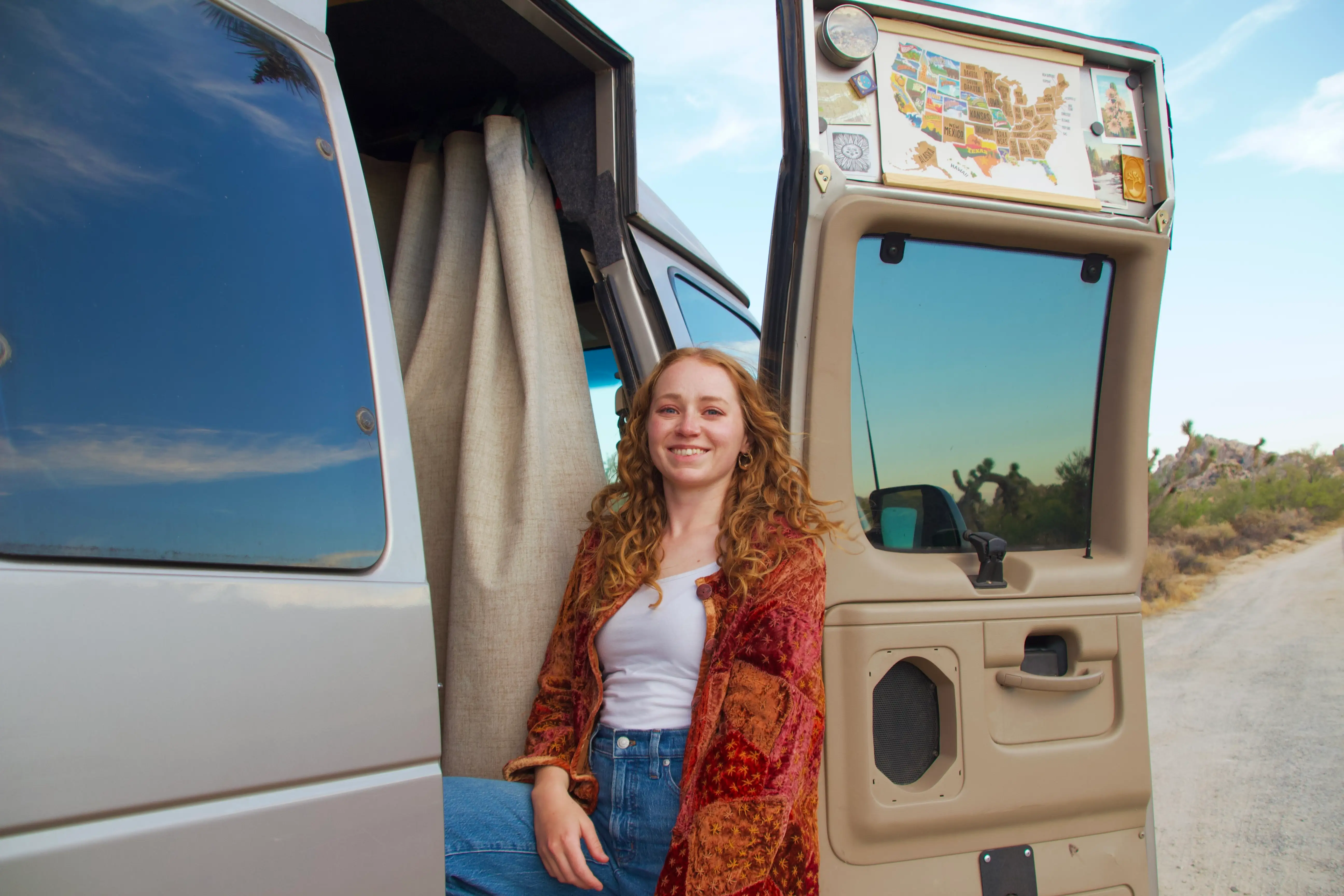Woman smiling as she steps out of van in Joshua Tree
