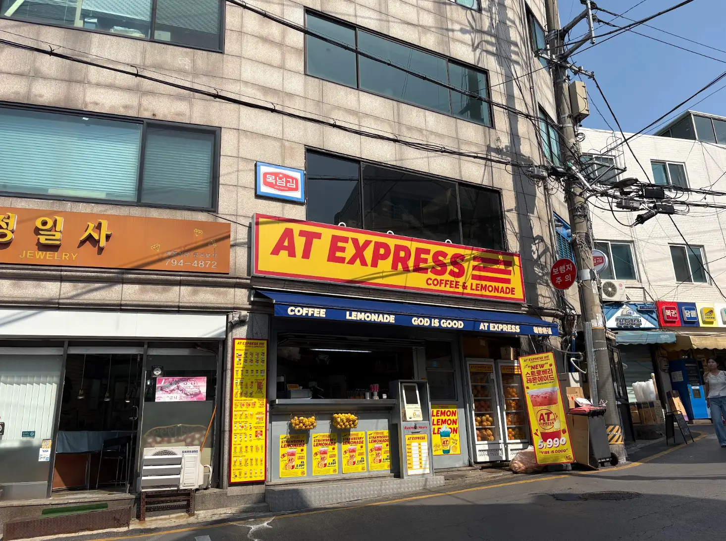 A street in Haebangchon, featuring a jewelry shop and an express coffee store.