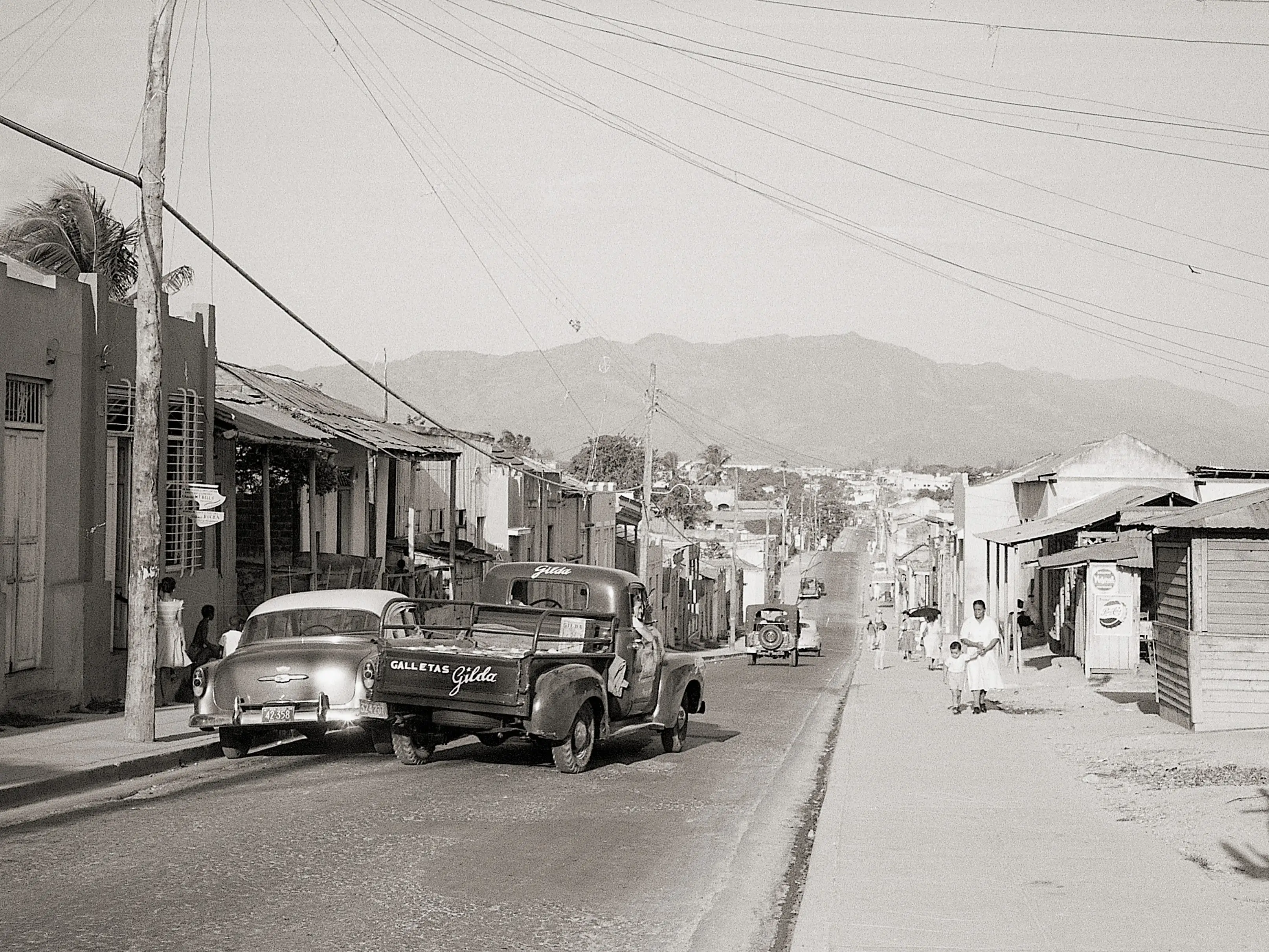 4/16/1958-Santiago De Cuba- Cuba seems to be at peace, if one were to judge from this peaceful looking street in Santiage De Cuba, April 15. On the horizon, however, rise the Sierra Maestra Mountains, where rebel leader Fidel Castro has his stronghold.