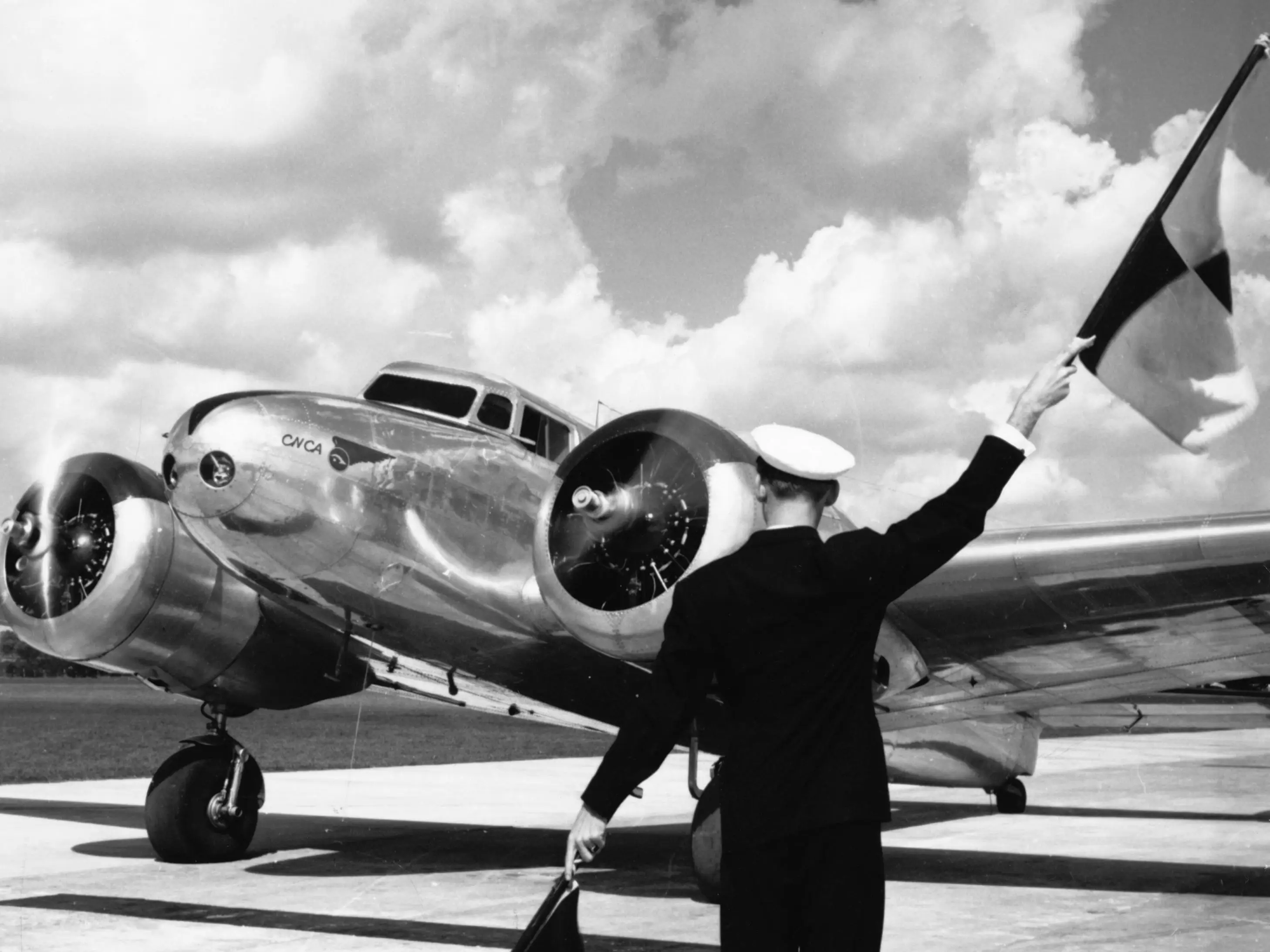Havana, Cuba: Rancho Boyeros Airport. Photo shows a worker flagging in a Lockheed Electra plane