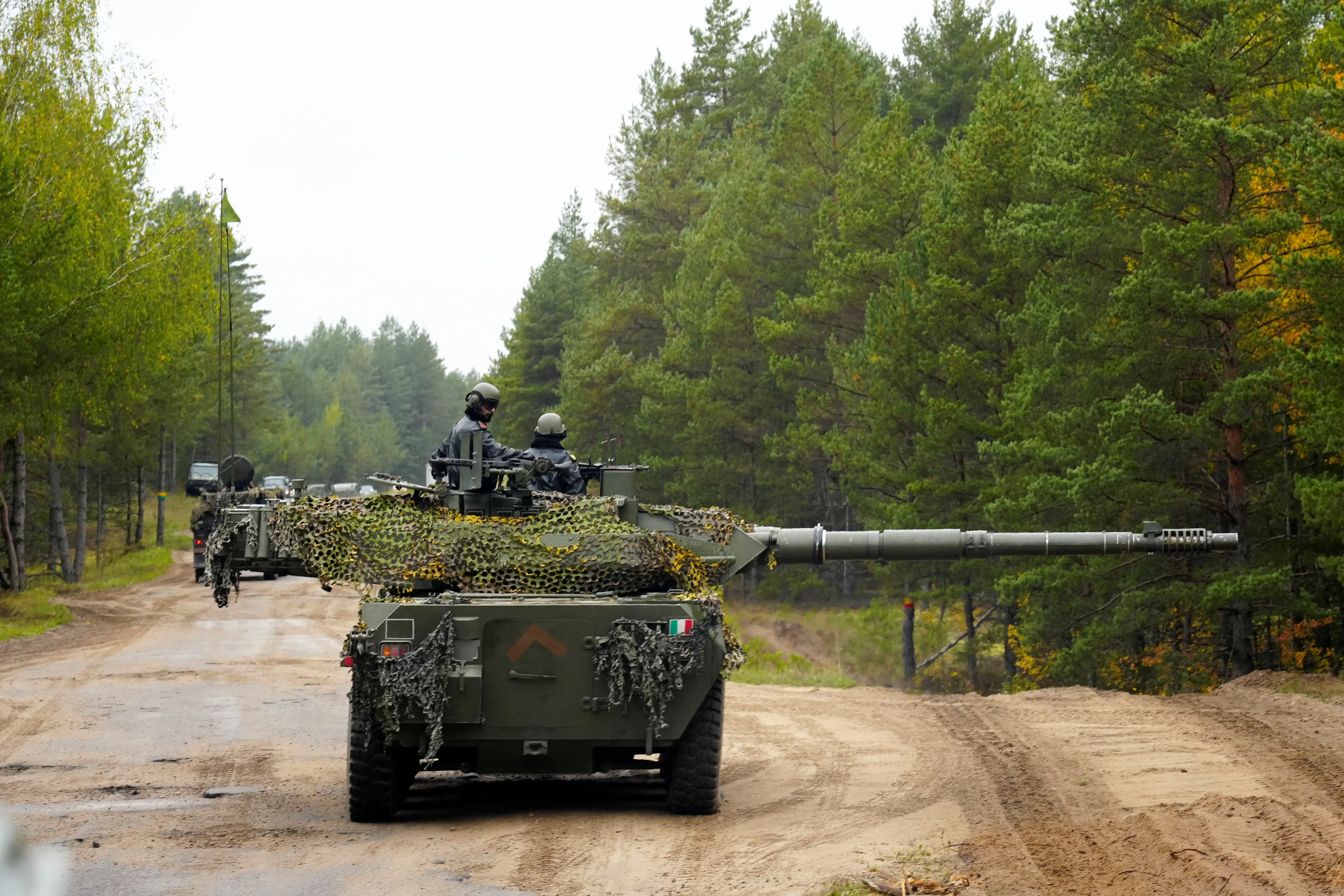 Two Italian soldiers look out from a B1 Centauro turret.