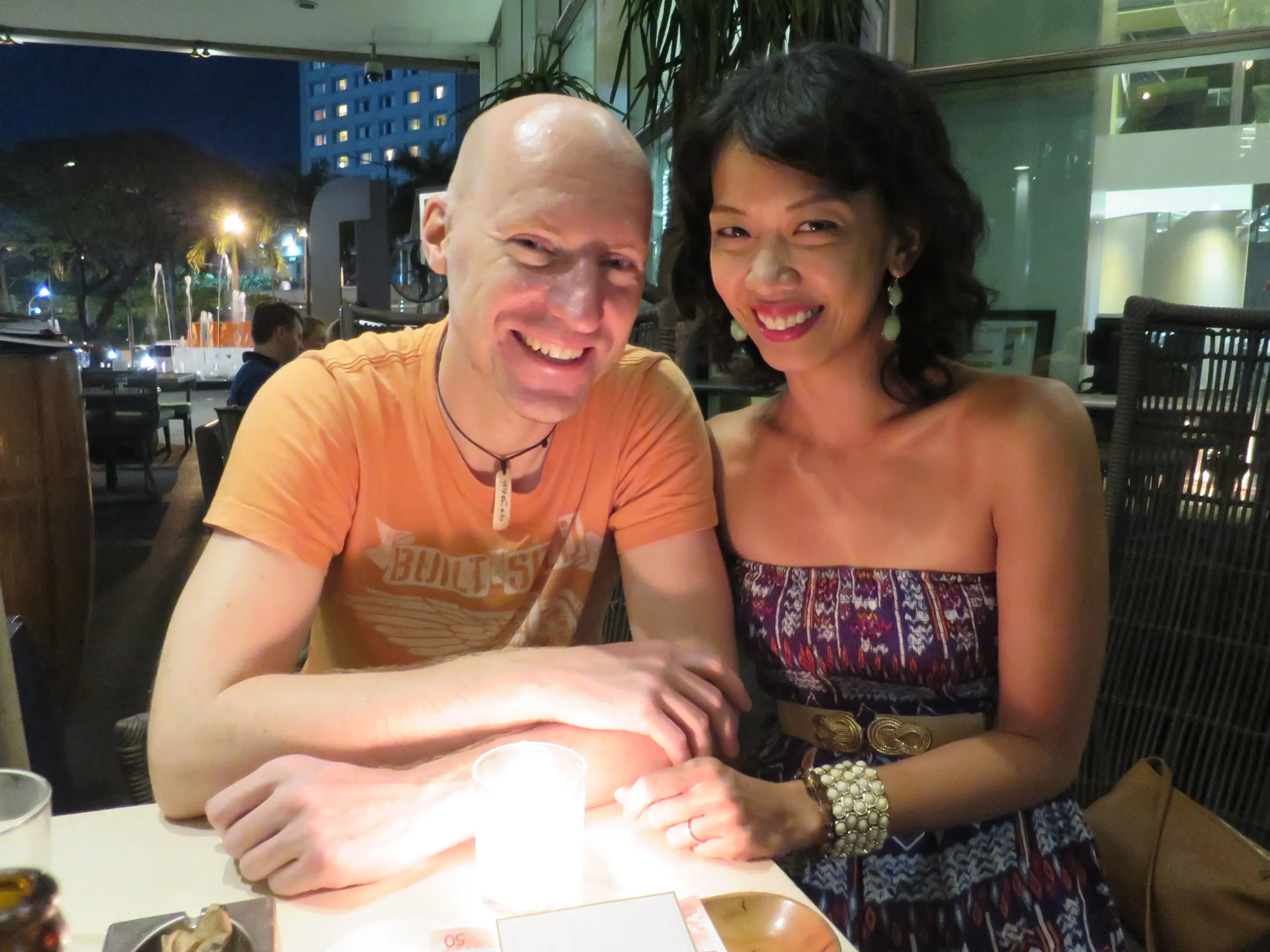 Fen and her husband are sitting at a restaurant table together.