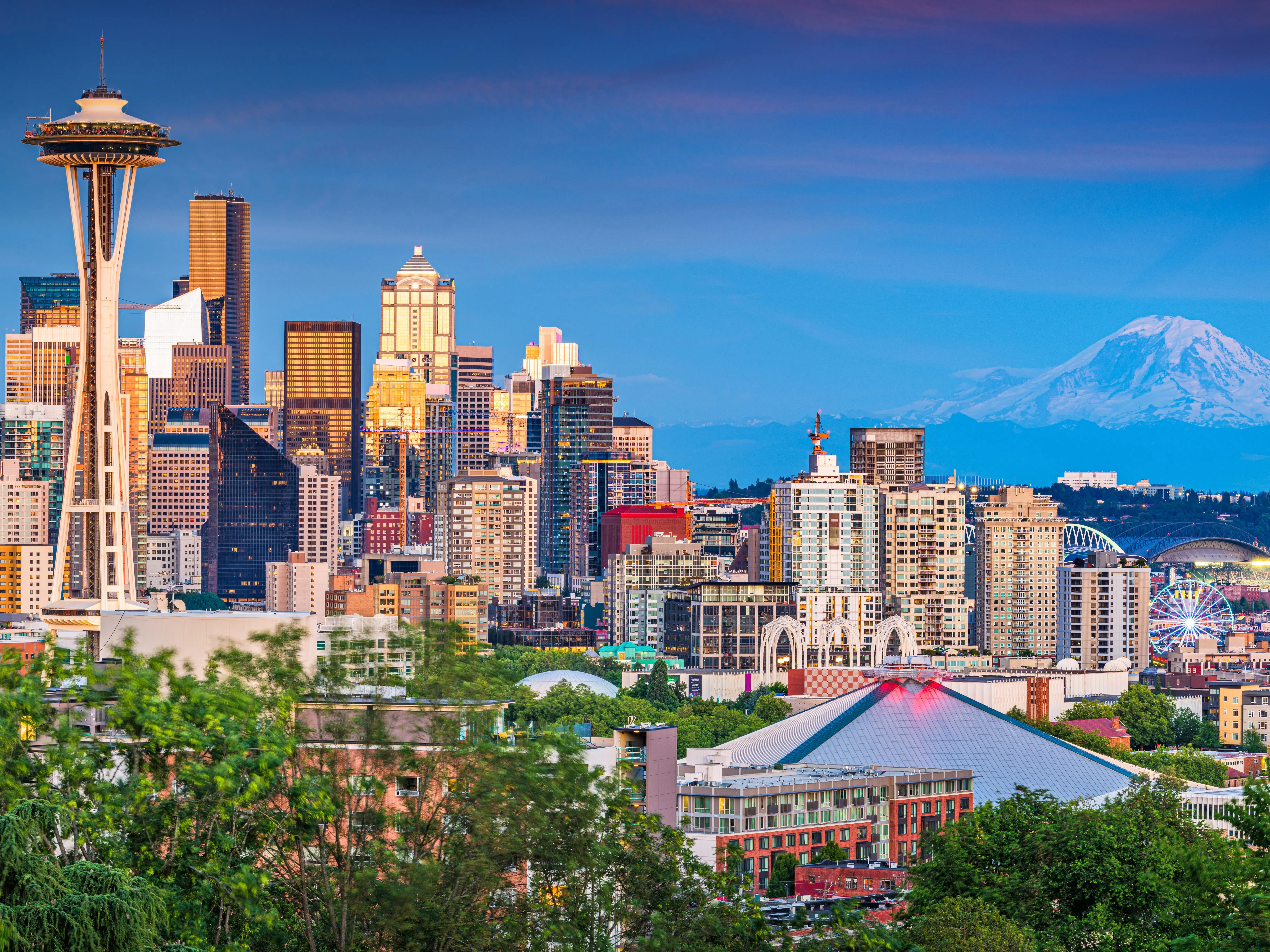 Beautiful panoramic view of Seattle skyline seen from Kerry Park at sunset in golden evening light with Mount Rainier in the background in summer, Washington State, United States of America