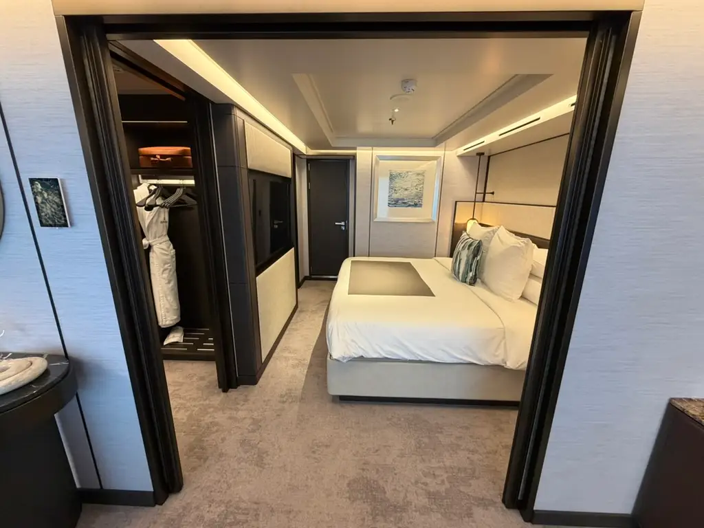 View of hotel room with large closet, bed, carpeting