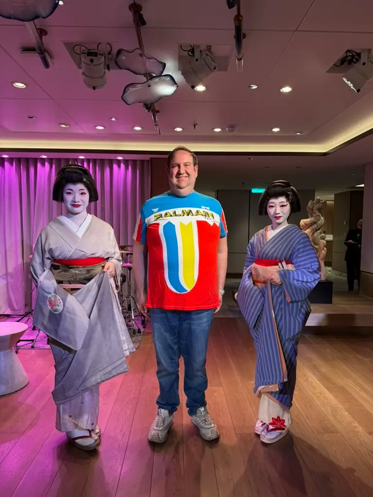 Man standing with two women wearing kimonos