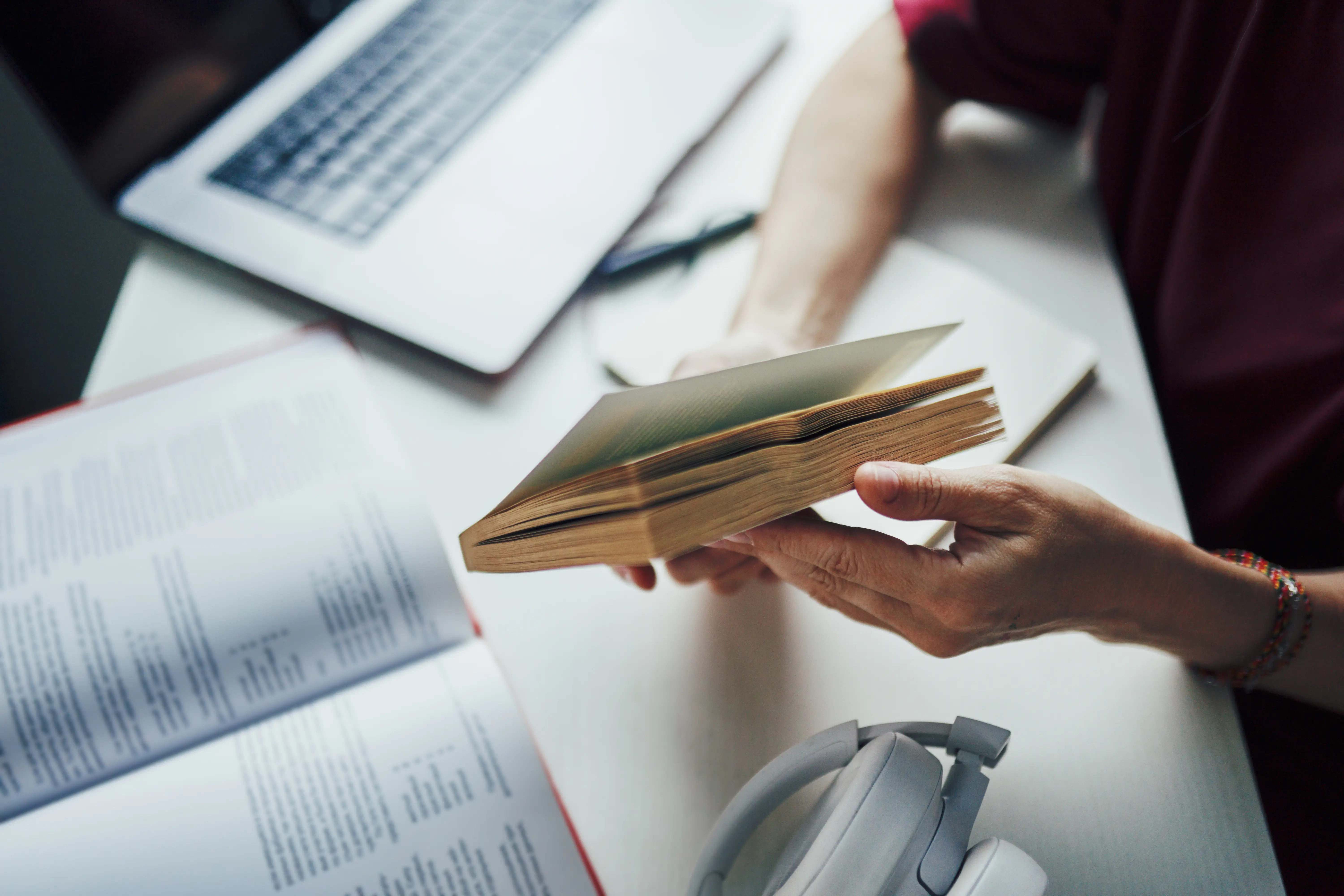 woman with study materials and a laptop at her desk