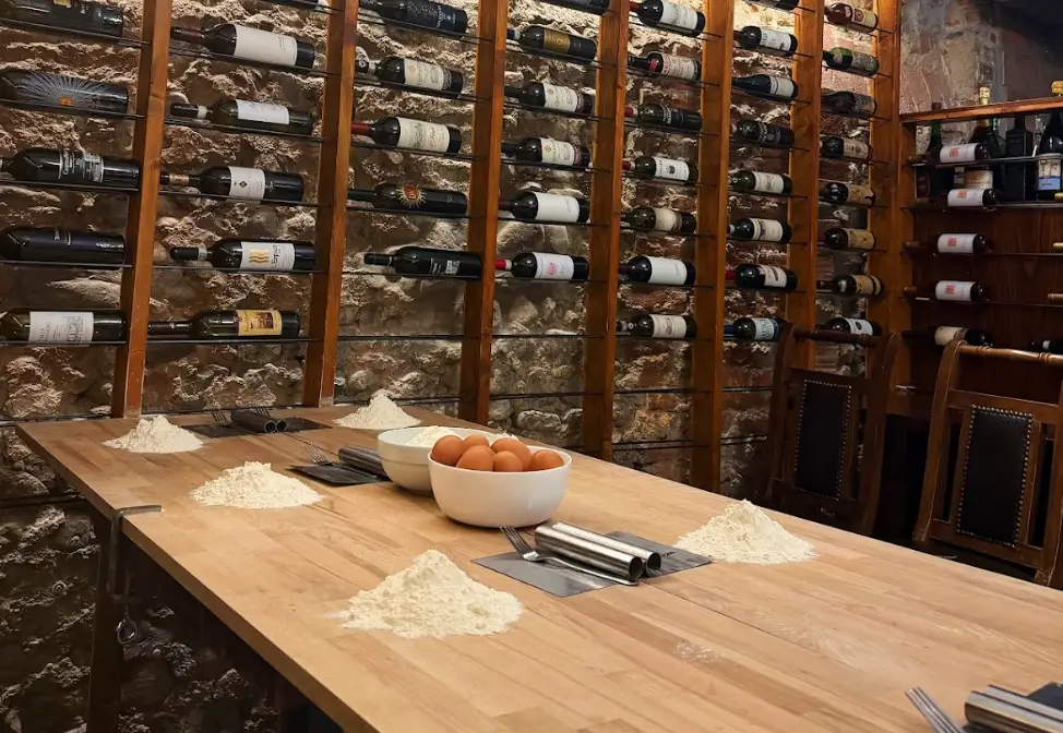 Mounds of flour and eggs with wine bottles in the background at a restaurant.