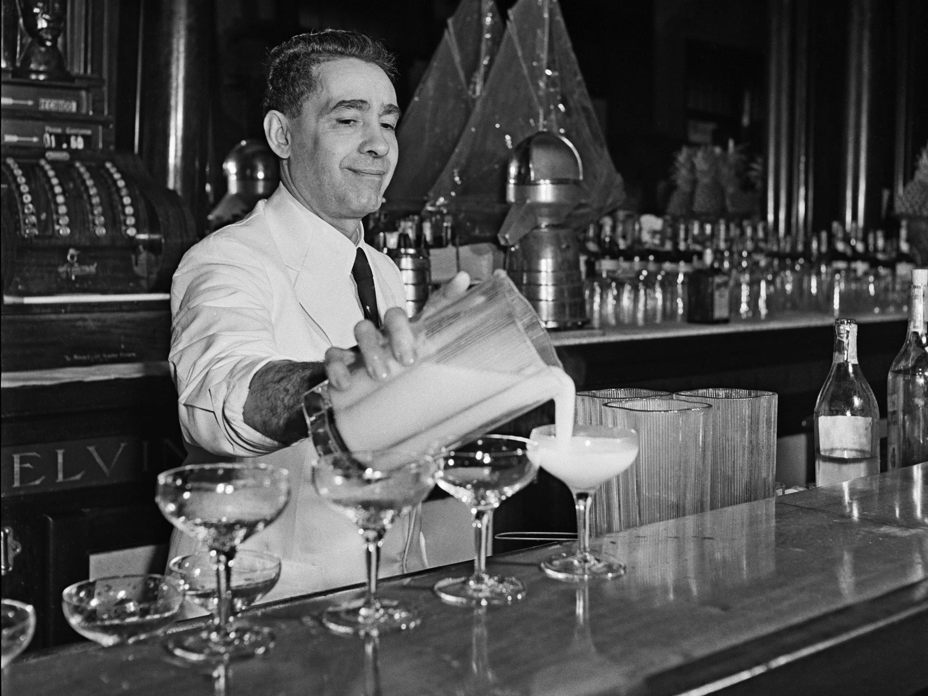 HAVANA CUBA - 1946: A bartender mixes an exotic tropical cocktail at a bar in 1946 in Havana, Cuba.