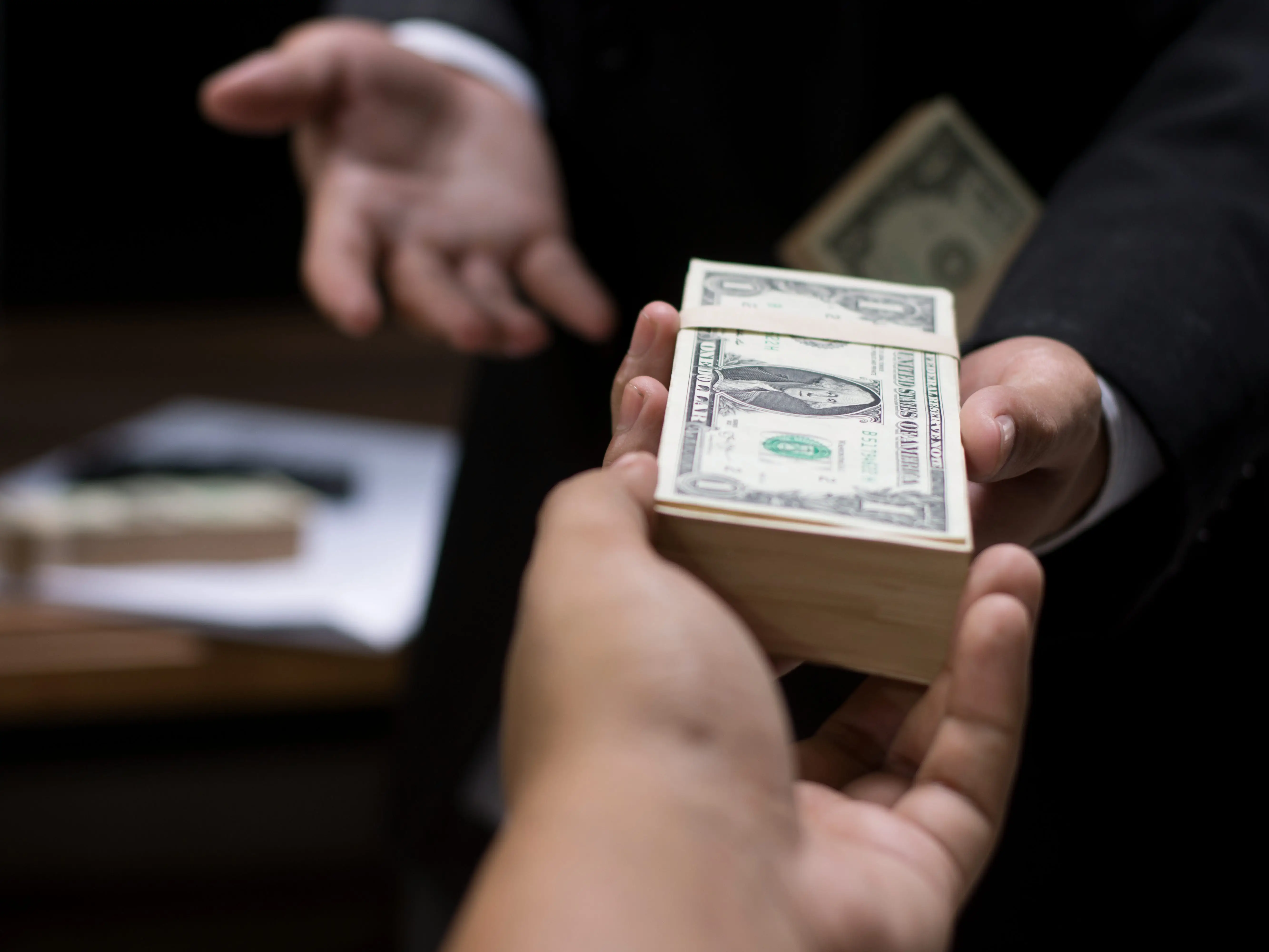 person handing money to another person